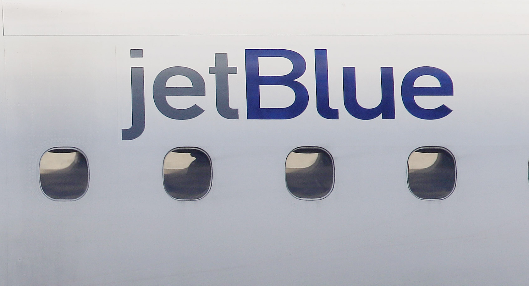 FILE - In this Jan. 20, 2011, file photo, a JetBlue logo is displayed on the side of a jet as it taxis at Boston's Logan International Airport. Federal investigators are describing a close call between planes at a Colorado airport last year. The National Transportation Safety Board said Wednesday, Dec. 13, 2023 that a JetBlue plane struck its tail on the ground because the captain took off quickly to avoid a plane that was preparing to land on the same runway. (AP Photo/Stephan Savoia, File)