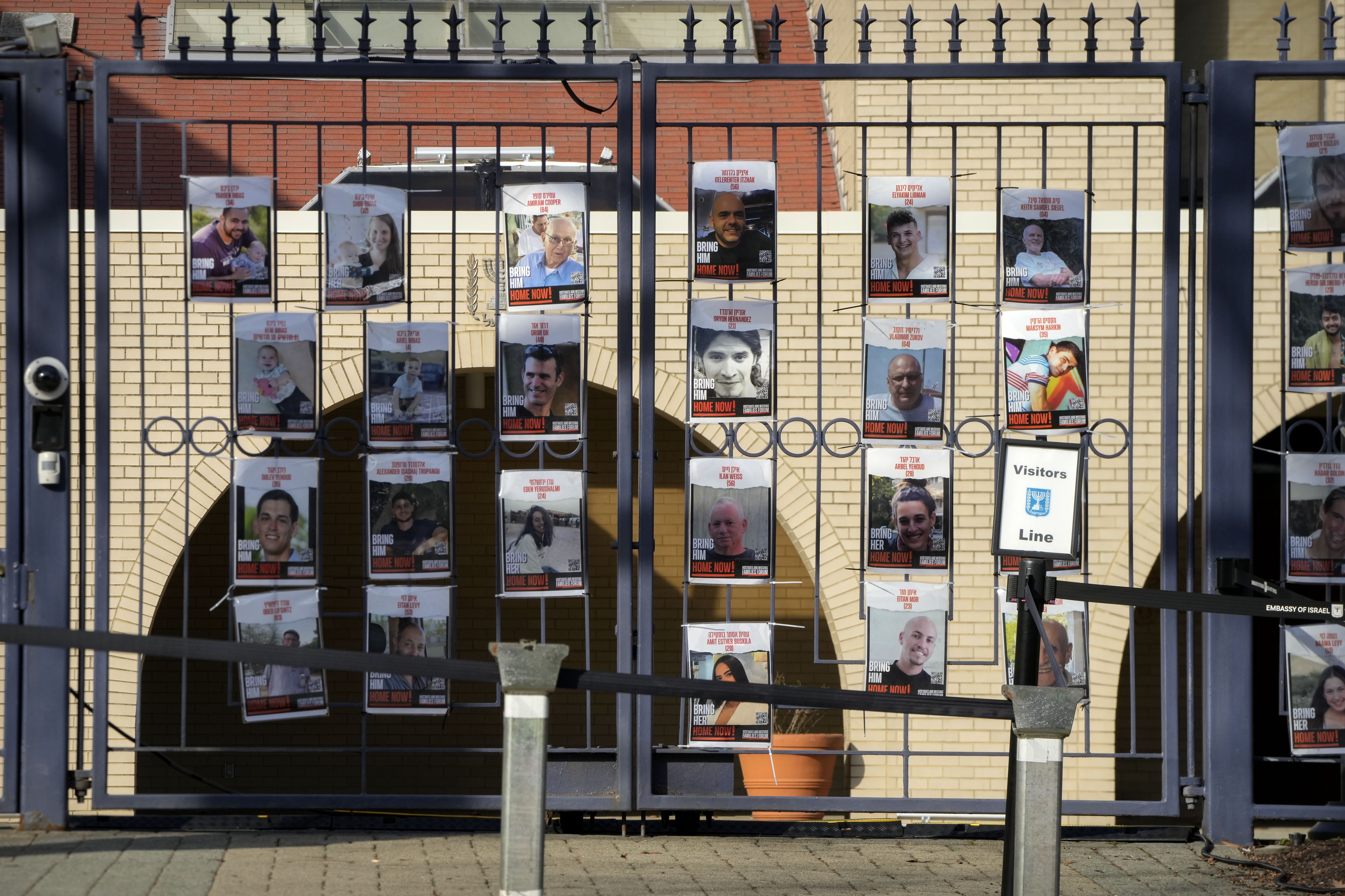 Posters of kidnapped people line the gates at the entrance of the Israeli Embassy, Monday, Feb. 26, 2024, in Washington. An active-duty member of the U.S. Air Force has died after he set himself ablaze outside the Israeli Embassy in Washington, D.C., while declaring that he "will no longer be complicit in genocide." (AP Photo/Mark Schiefelbein)