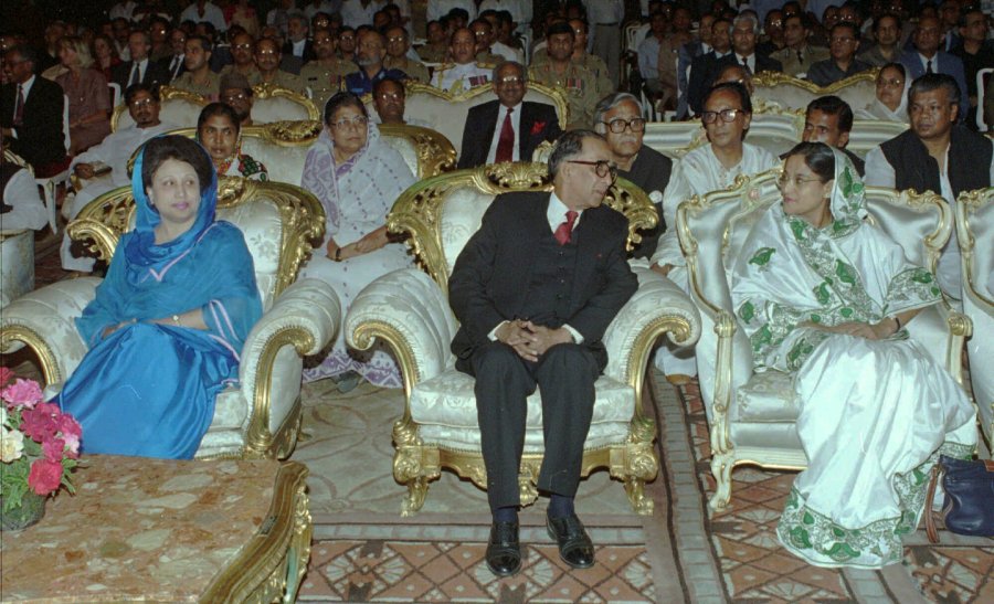 FILE- Former Bangladeshi Prime Minister Khaleda Zia, left, looks over as new interim leader Mohammad Habibur Rahman speaks with opposition Awami League leader Sheikh Hasina, right, at Rahman's swearing-in ceremony in Dhaka Saturday, March 30, 1996. (AP Photo/Pavel Rahman, File)