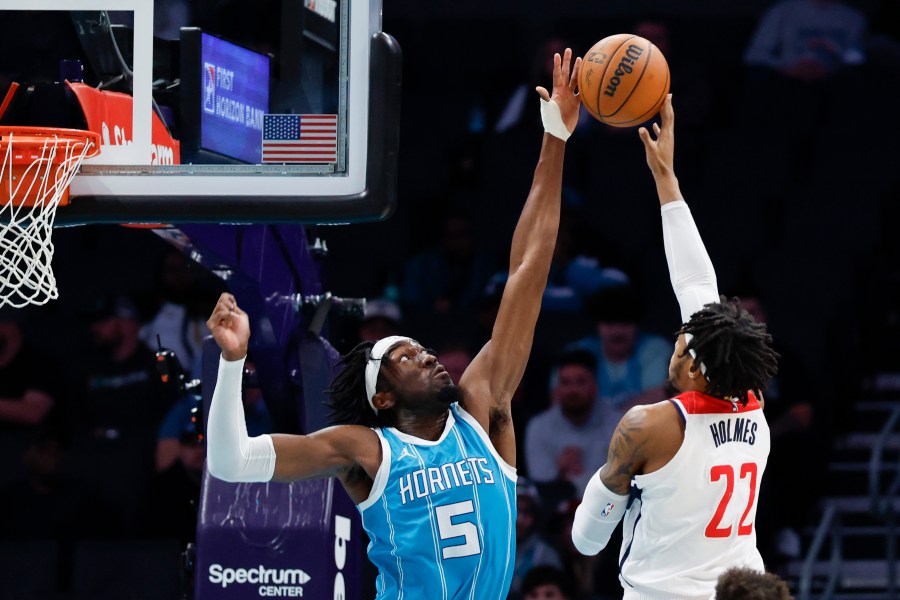 Charlotte Hornets center Mark Williams (5) blocks a shot by Washington Wizards forward Richaun Holmes (22) during the first half of an NBA basketball game in Charlotte, N.C., Monday, Feb. 3, 2025. (AP Photo/Nell Redmond)