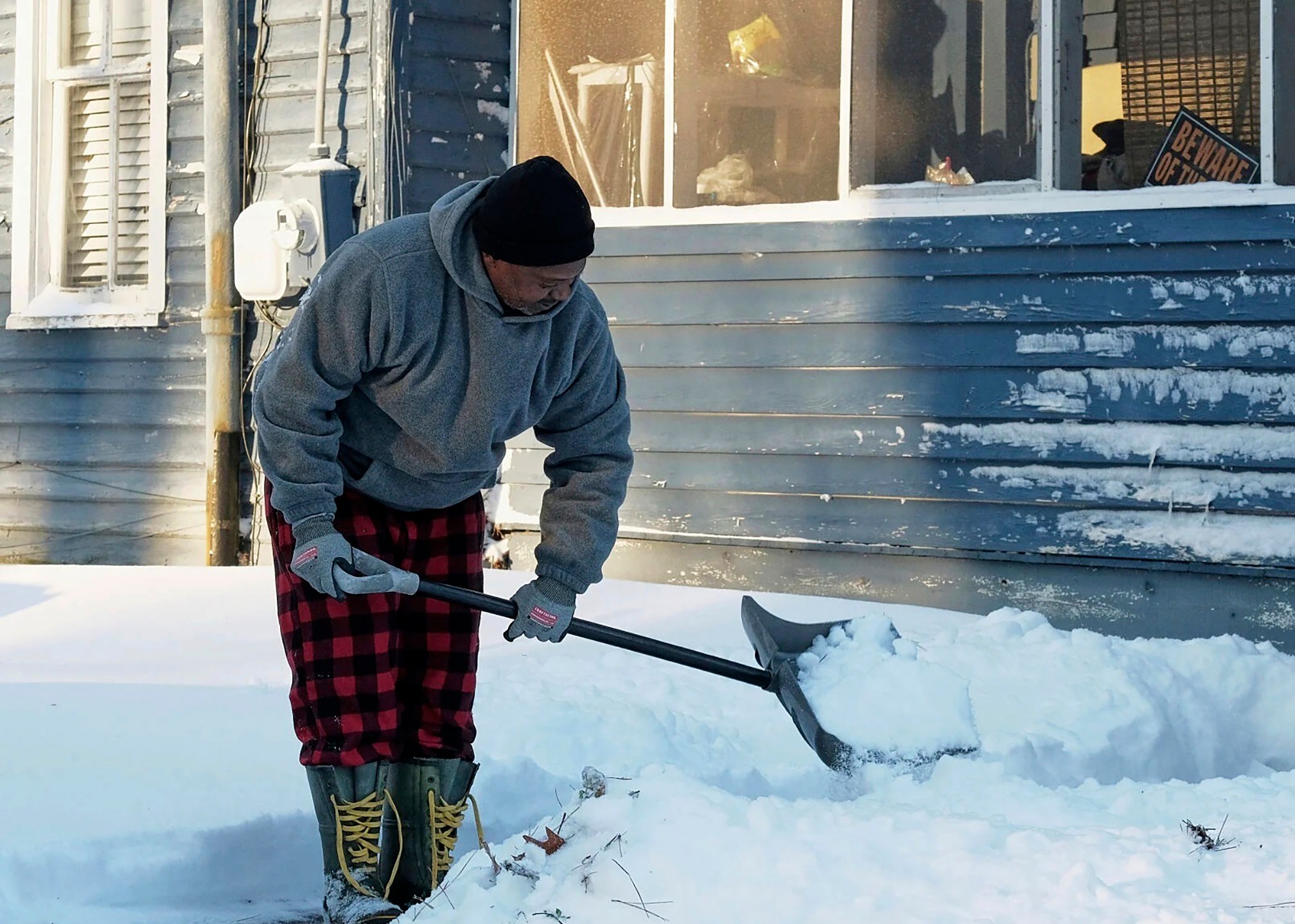 Derrick Tillett shovels the snow off the sidewalk leading from his house to the street in Elizabeth City, N.C., Thursday, Feb. 20, 2025. (Chris Day/The Daily Advance via AP)