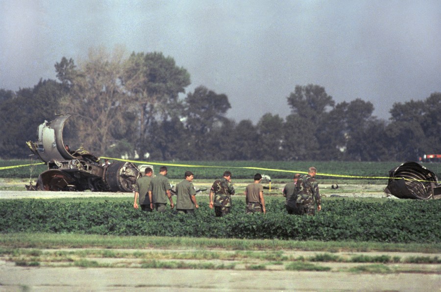 FILE - In this July 20, 1989 file photo Iowa Air National Guard soldiers search a field near the burned engine of United Airlines Flight 232 after the McDonnell Douglas DC-10 carrying nearly 300 people crash landed at the Sioux City, Iowa, airport. (AP Photo/James Finley, File)