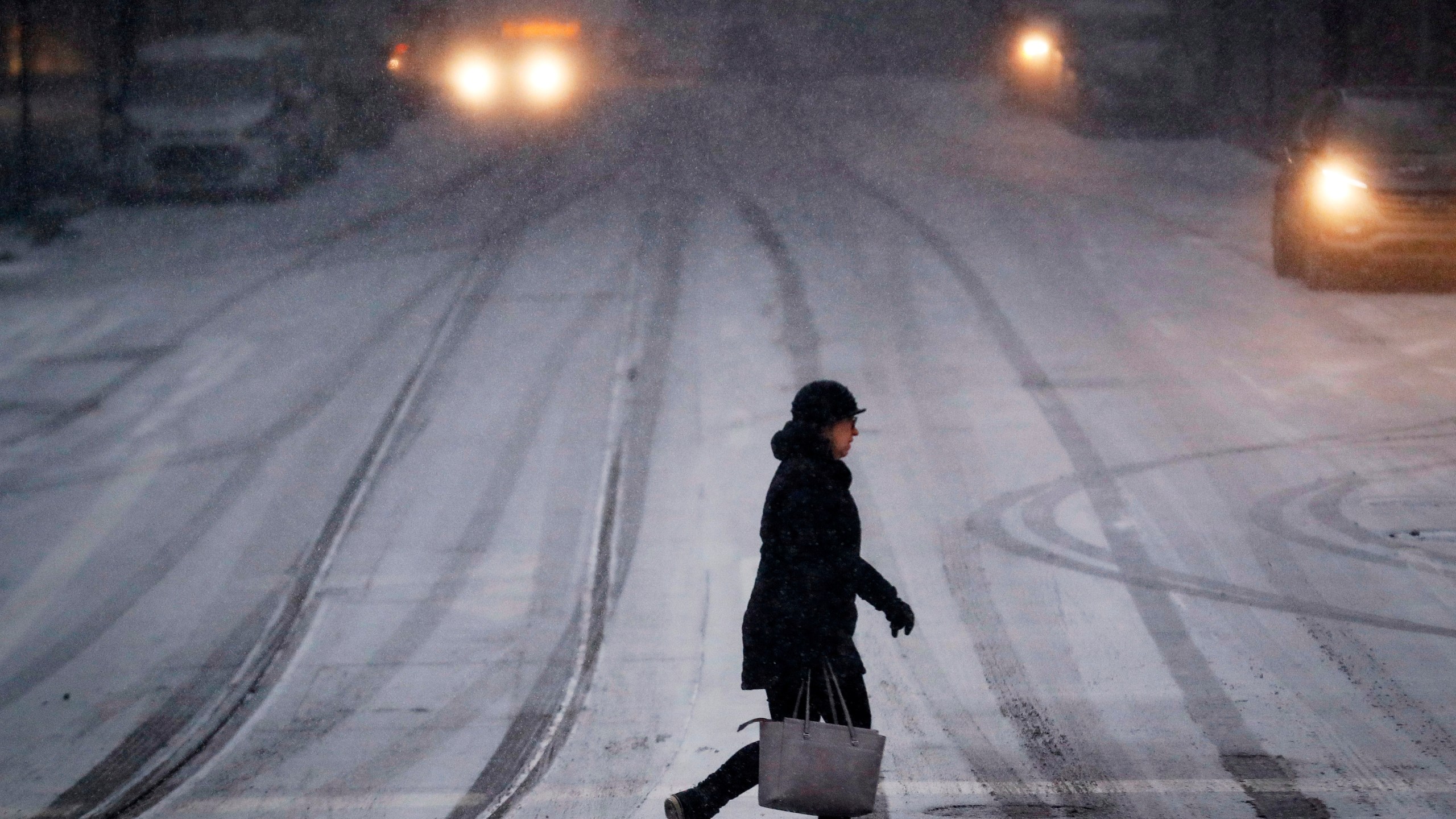 FILE - A commuter braves the wind and snow in frigid weather, Jan. 30, 2019, in Cincinnati. (AP Photo/John Minchillo, File)