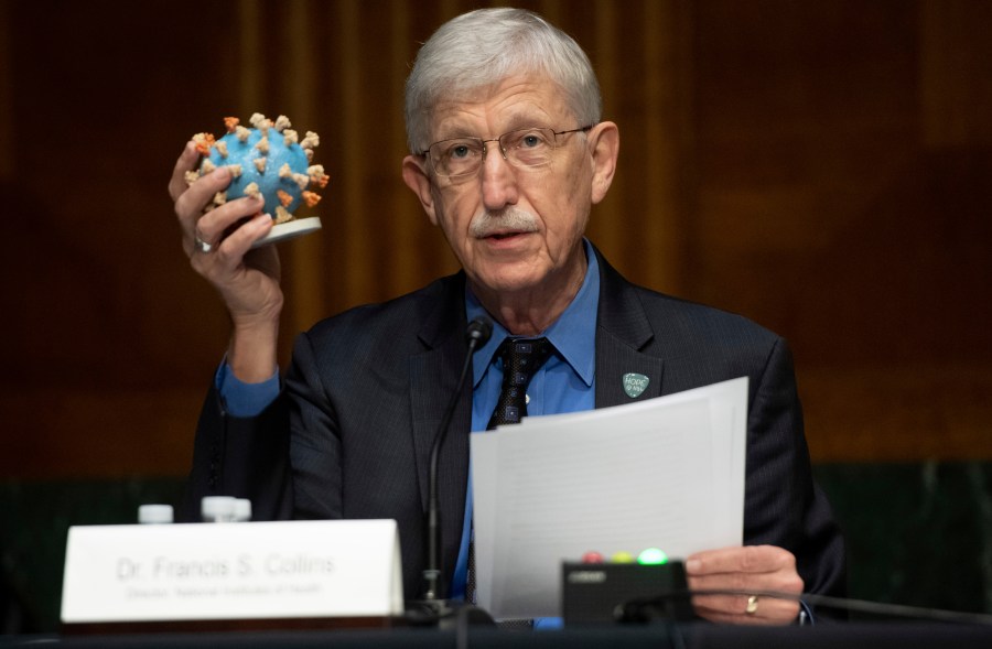 FILE- Dr. Francis Collins, Director of the National Institutes of Health (NIH), holds up a model of COVID-19, known as coronavirus, during a Senate Appropriations subcommittee hearing on the plan to research, manufacture and distribute a coronavirus vaccine, known as Operation Warp Speed, Thursday, July 2, 2020, on Capitol Hill in Washington. (Saul Loeb/Pool Photo via AP, File)
