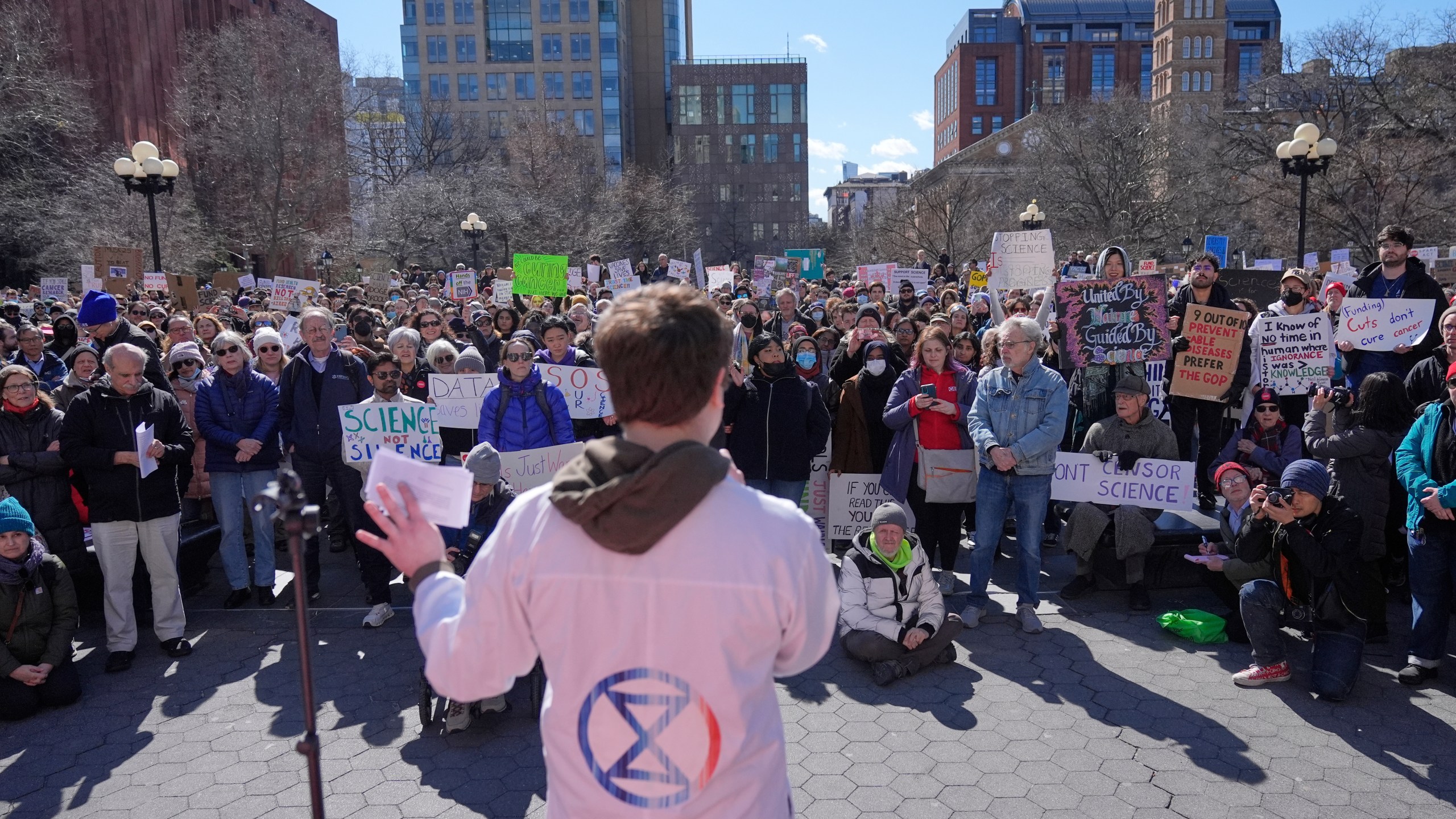 People listen to Griffin Gowdy, a PhD student at Columbia University, speak during a "Stand Up for Science" rally in New York, Friday, March 7, 2025. (AP Photo/Seth Wenig)
