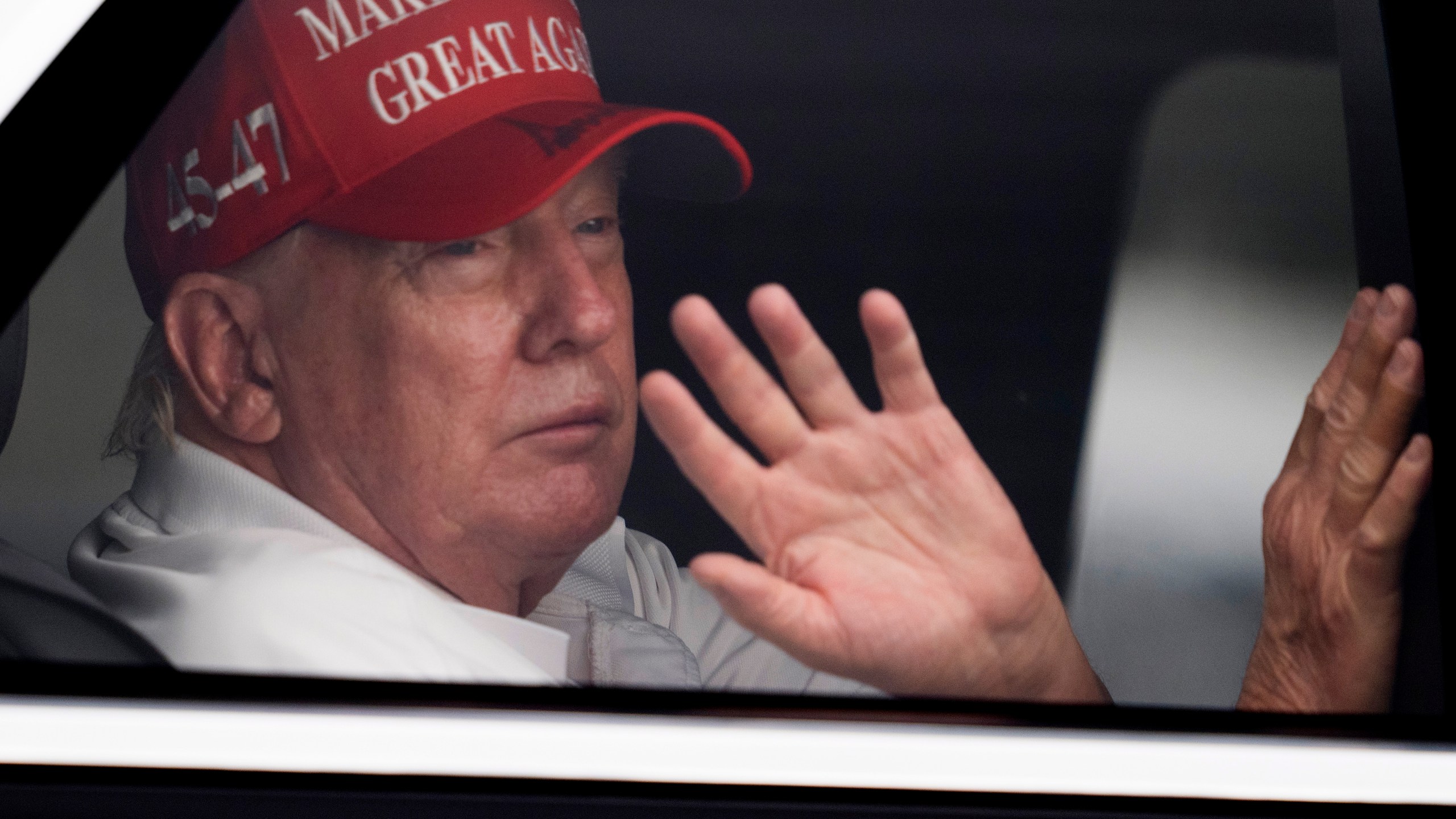 President Donald Trump waves to supporters from his limousine as he arrives at Trump International Golf Club, Saturday, March 29, 2025, in West Palm Beach, Fla. (AP Photo/Manuel Balce Ceneta)