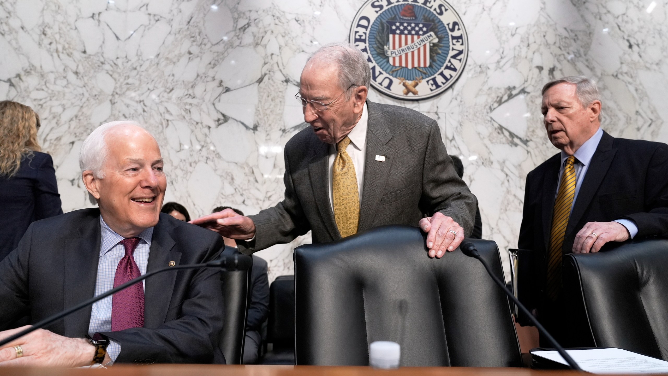 Senate Judiciary Committee Chairman Chuck Grassley, R- Iowa, center, greets Sen. John Cornyn, R-Texas, left, while Sen. Dick Durbin, D-Ill., arrives at right as the panel meets to consider prescription drug pricing and other measures, at the Capitol in Washington, Thursday, April 3, 2025. (AP Photo/J. Scott Applewhite)
