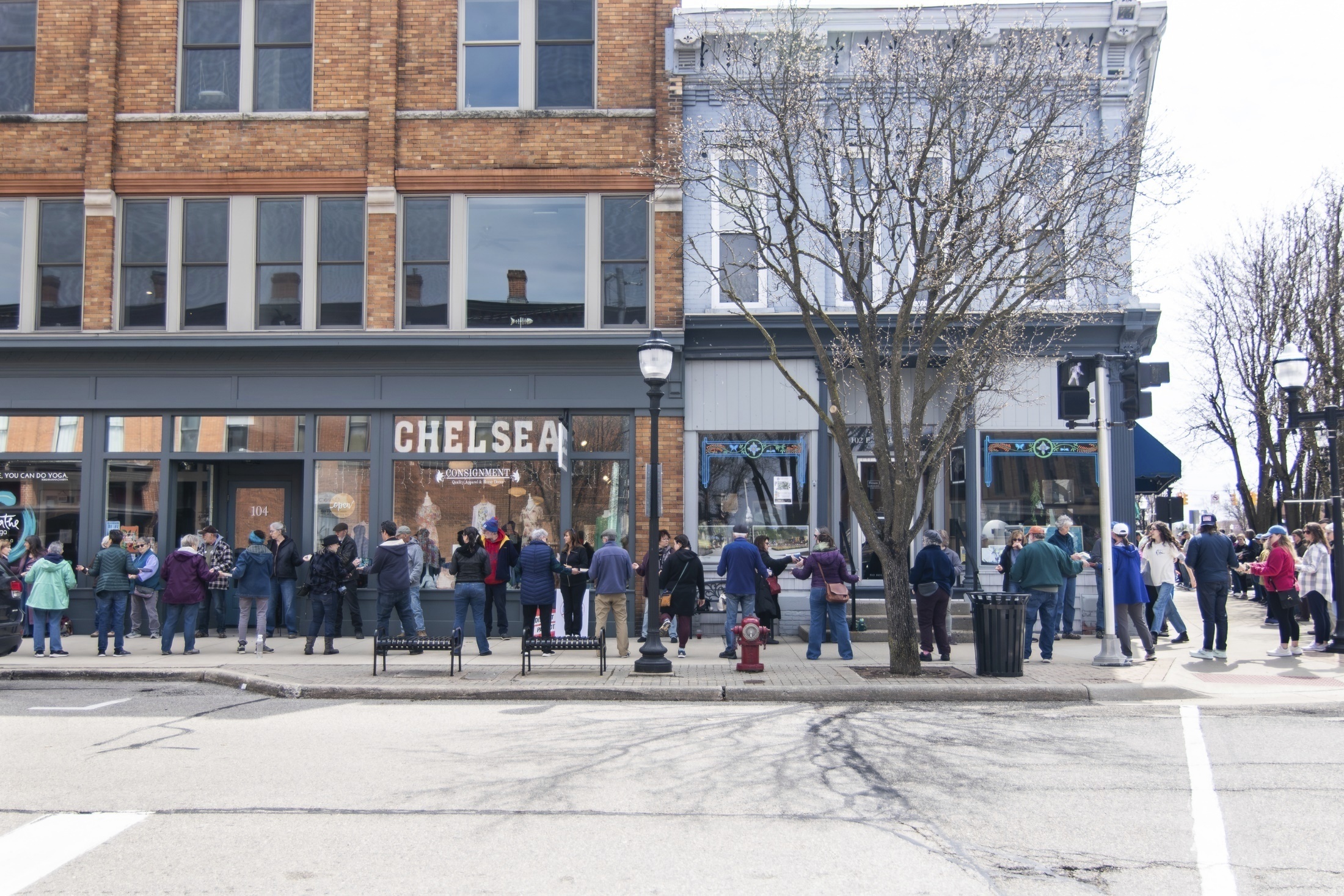 In this photo provided by Burrill Strong, supporters of Serendipity Books pass the store's books hand to hand, helping move the business to a new storefront about a block away from its current location, Sunday, April 13, 2025, in Chelsea, Mich. (Burrill Strong via AP)