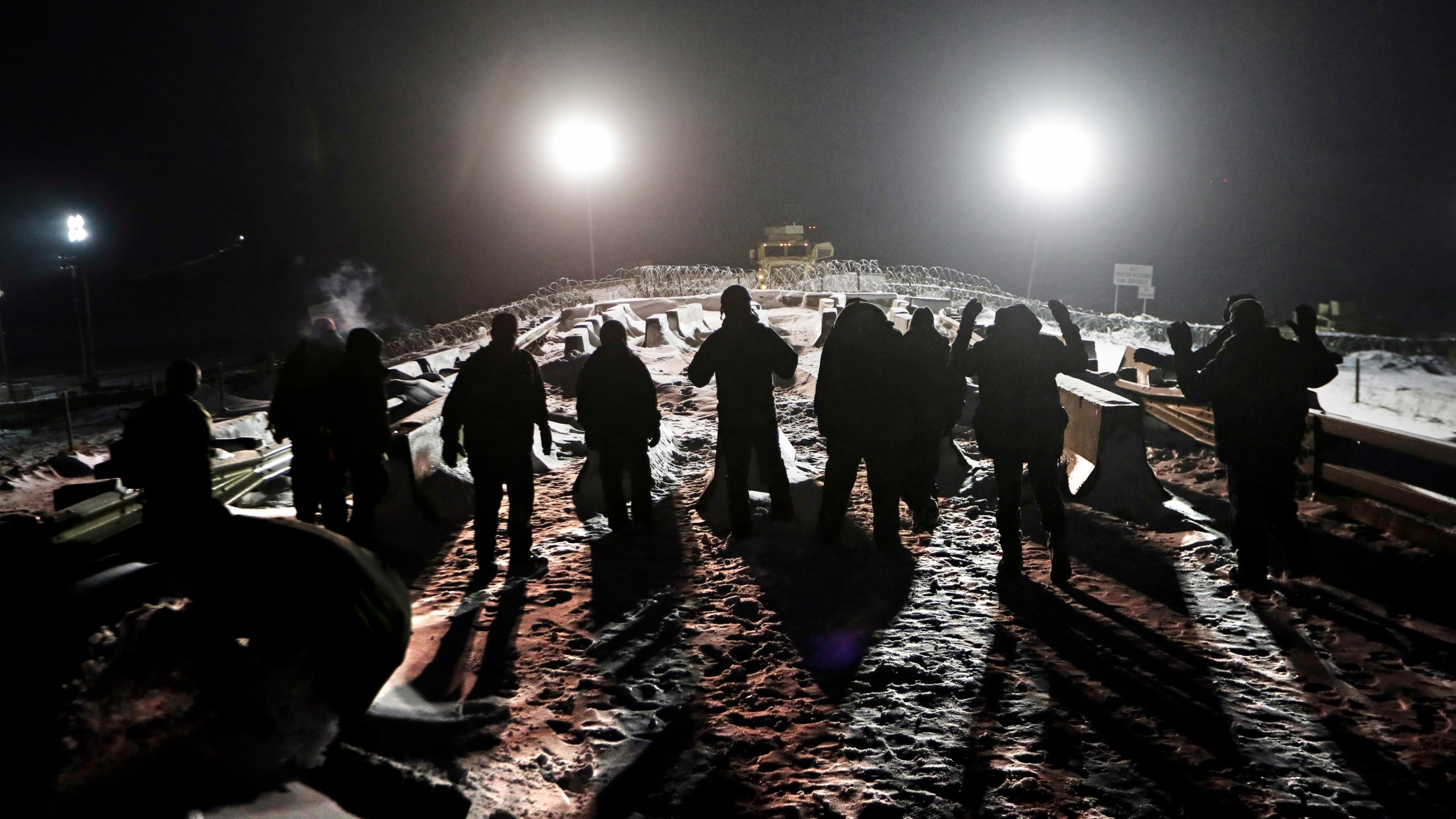 FILE - Military veterans walk onto a closed bridge to protest across from police protecting the Dakota Access oil pipeline site in Cannon Ball, N.D., Thursday, Dec. 1, 2016. (AP Photo/David Goldman, File)