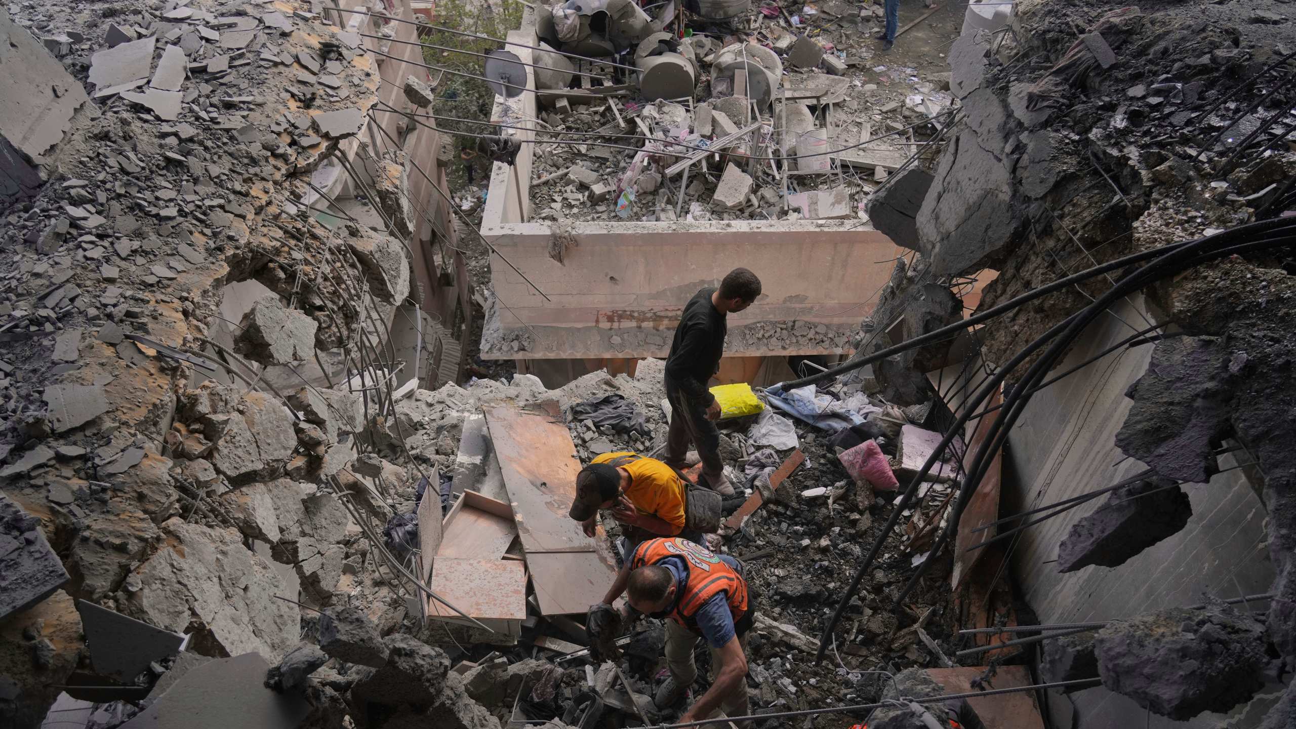 Palestinian men search through the debris following an Israeli airstrike on a residential building in Gaza City, Thursday, April 24, 2025. (AP Photo/Jehad Alshrafi)