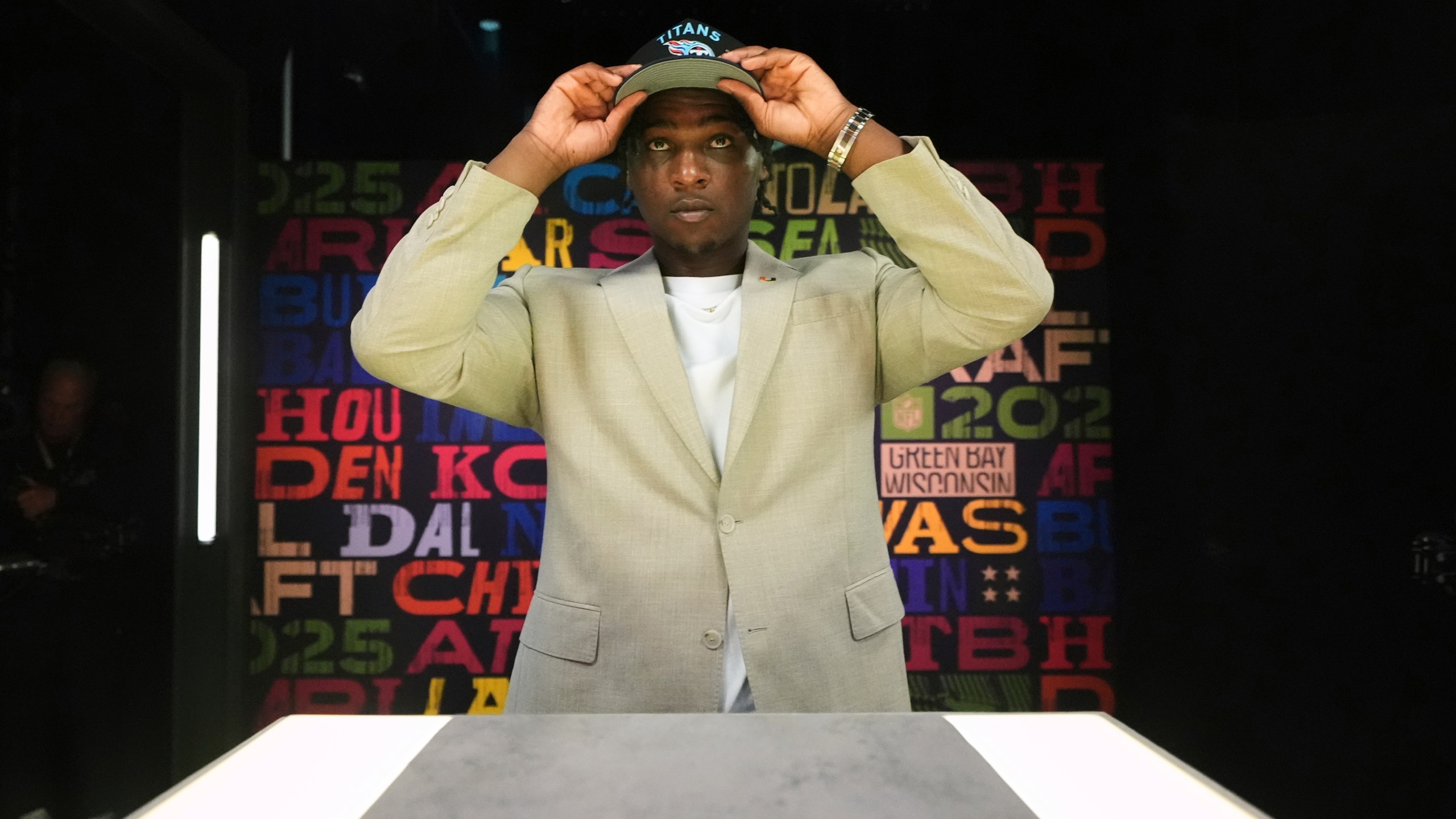 Miami quarterback Cam Ward puts on a hat after being chosen by the Tennessee Titans with the first overall pick during the first round of the NFL football draft, Thursday, April 24, 2025, in Green Bay, Wis. (AP Photo/Jeff Roberson)