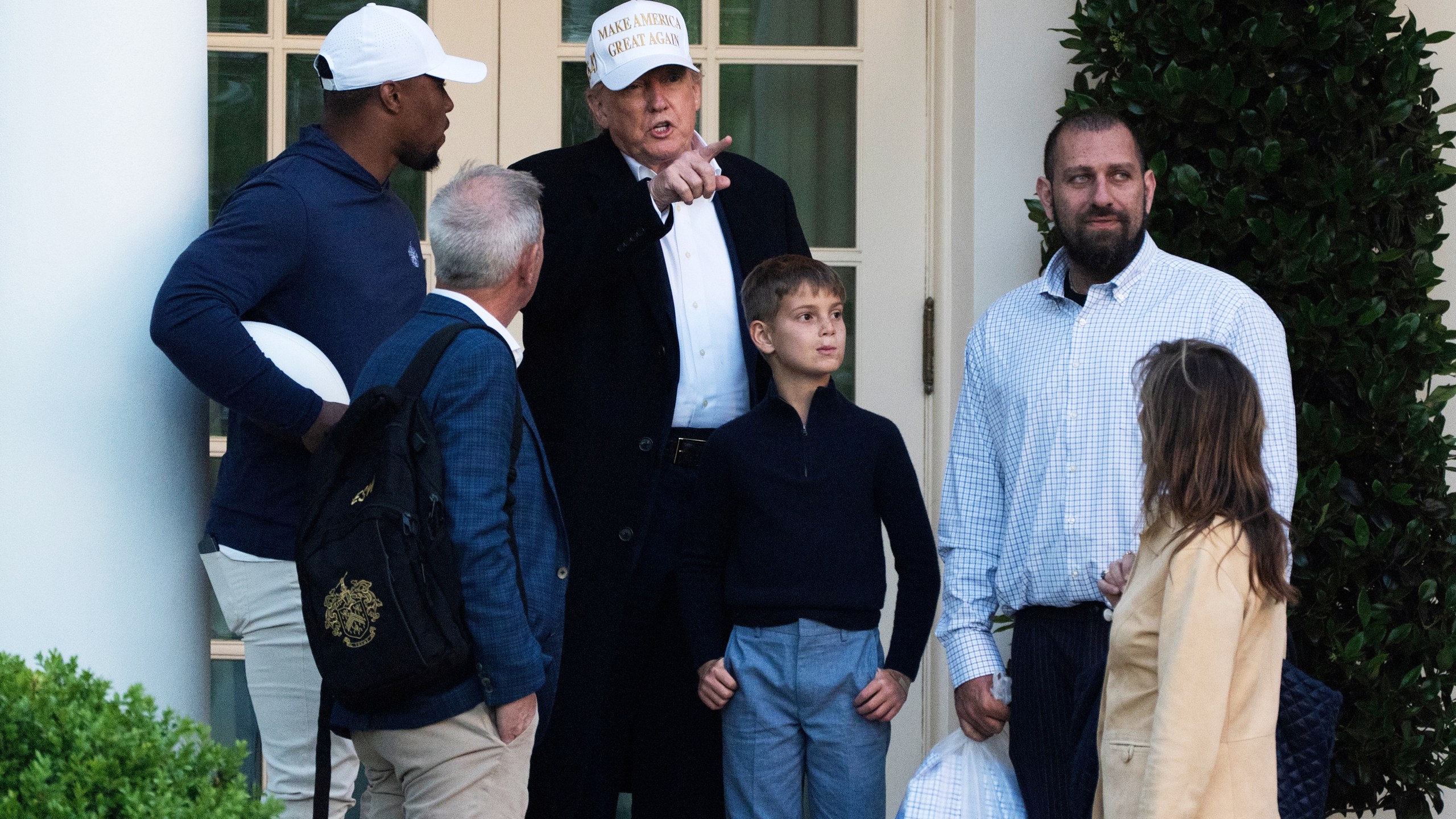 President Donald Trump with his grandson, Theodore Kushner, fourth from left, talks to Philadelphia Eagles football player Saquon Barkley, left, and other guests as he arrives at the White House, Sunday, April 27, 2025, in Washington. (AP Photo/Manuel Balce Ceneta)