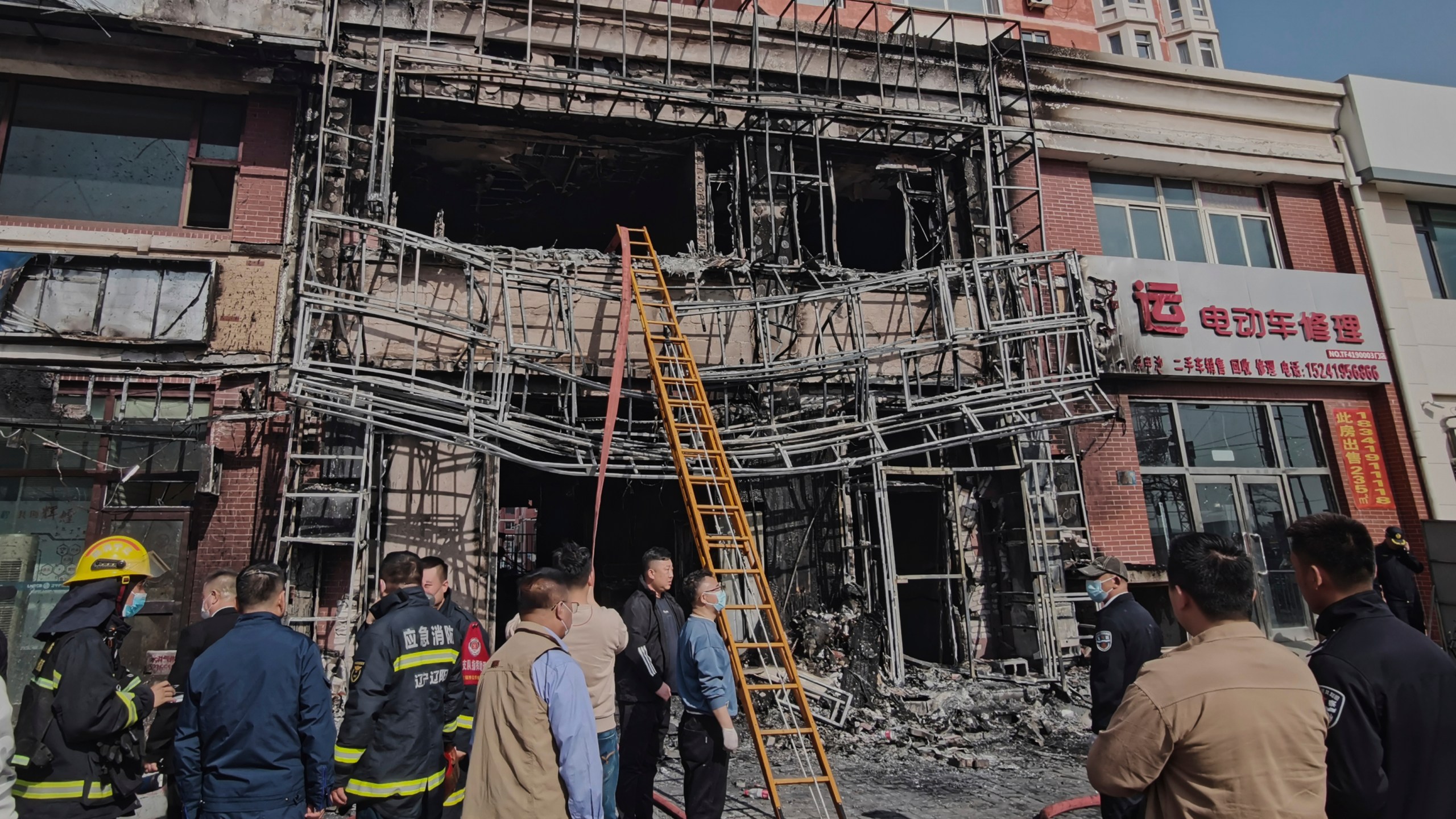 In this photo released by Xinhua News Agency, firefighters and officials survey the site of a restaurant fire in Liaoyang, northeastern China's Liaoning province on Tuesday, April 29, 2025. (Xinhua via AP)