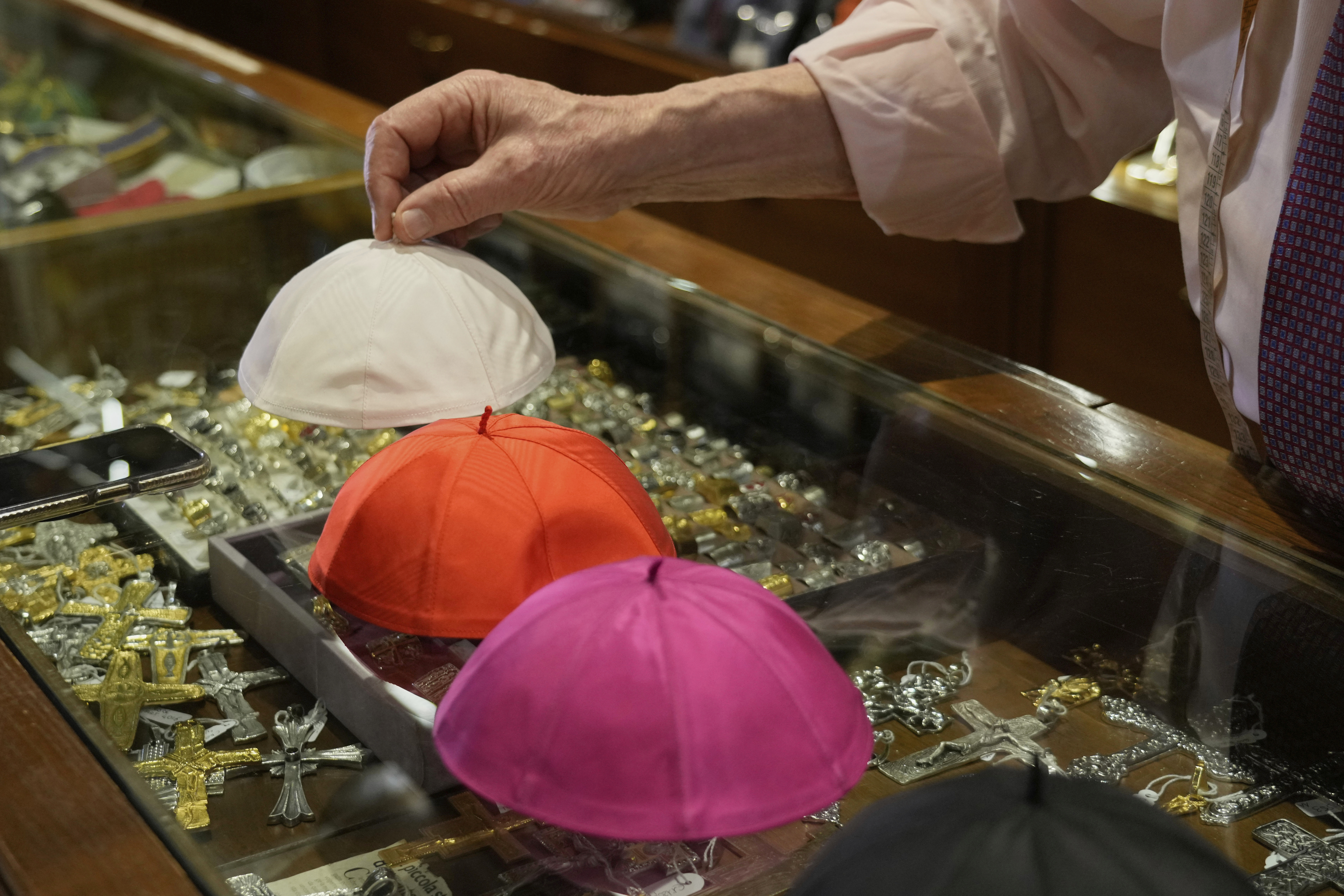 Italian tailor Raniero Mancinelli, who on his own initiative is making outfits for a possible future Pope, shows a pontiff's skull cap as he is interviewed by the Associated Press inside his shop, in Rome, Wednesday, April 30, 2025. (AP Photo/Gregorio Borgia)