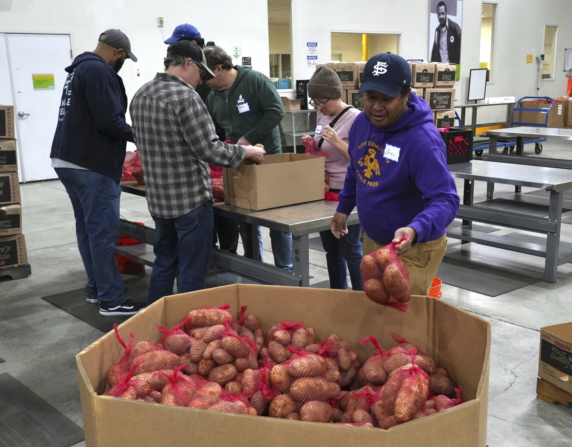Volunteers pack produce at the Alameda County Community Food Bank in Alameda, Calif., on Friday, April 25, 2025. (AP Photo/Terry Chea)