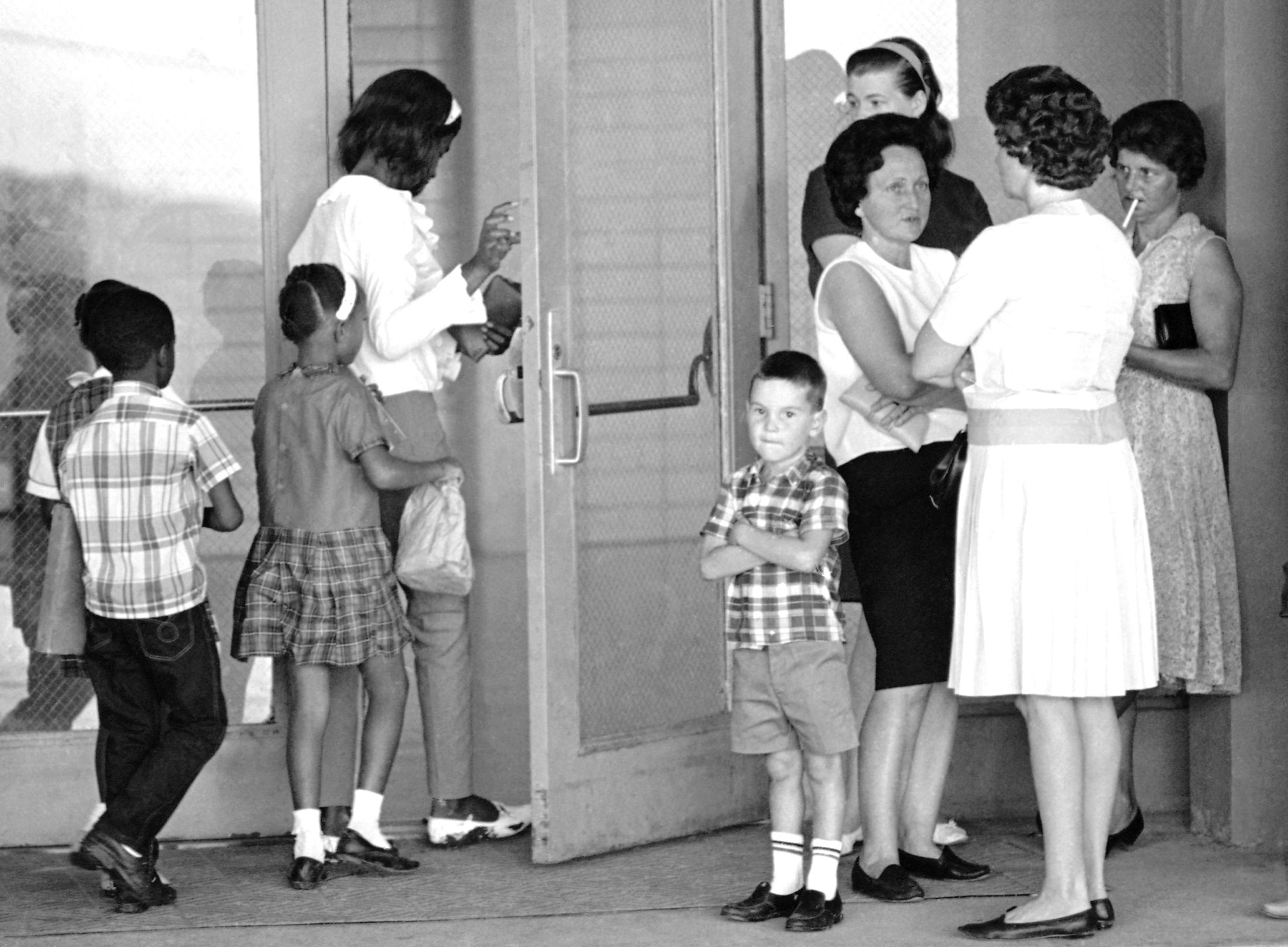 FILE - A group of African American students, left, enter the Boothville-Venice School in Plaquemines Parish, Louisiana on Sept. 12, 1966 as a group of white mothers wait at the entrance of the school. (AP Photo/Jack Thornell, file)