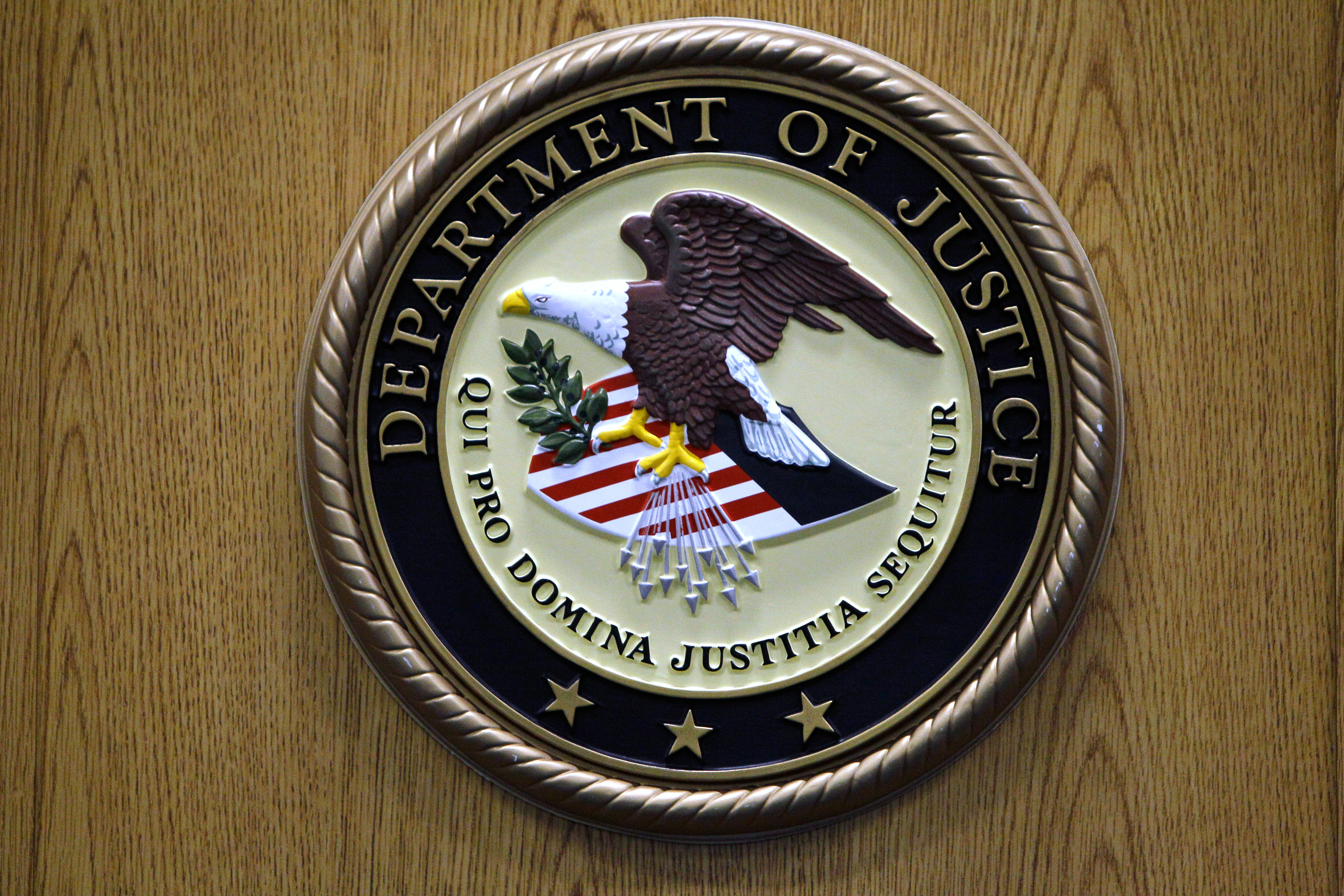 FILE - A Department of Justice logo is shown on a podium during a news conference, Sept. 30, 2010, in Philadelphia. (AP Photo/Matt Slocum, file)