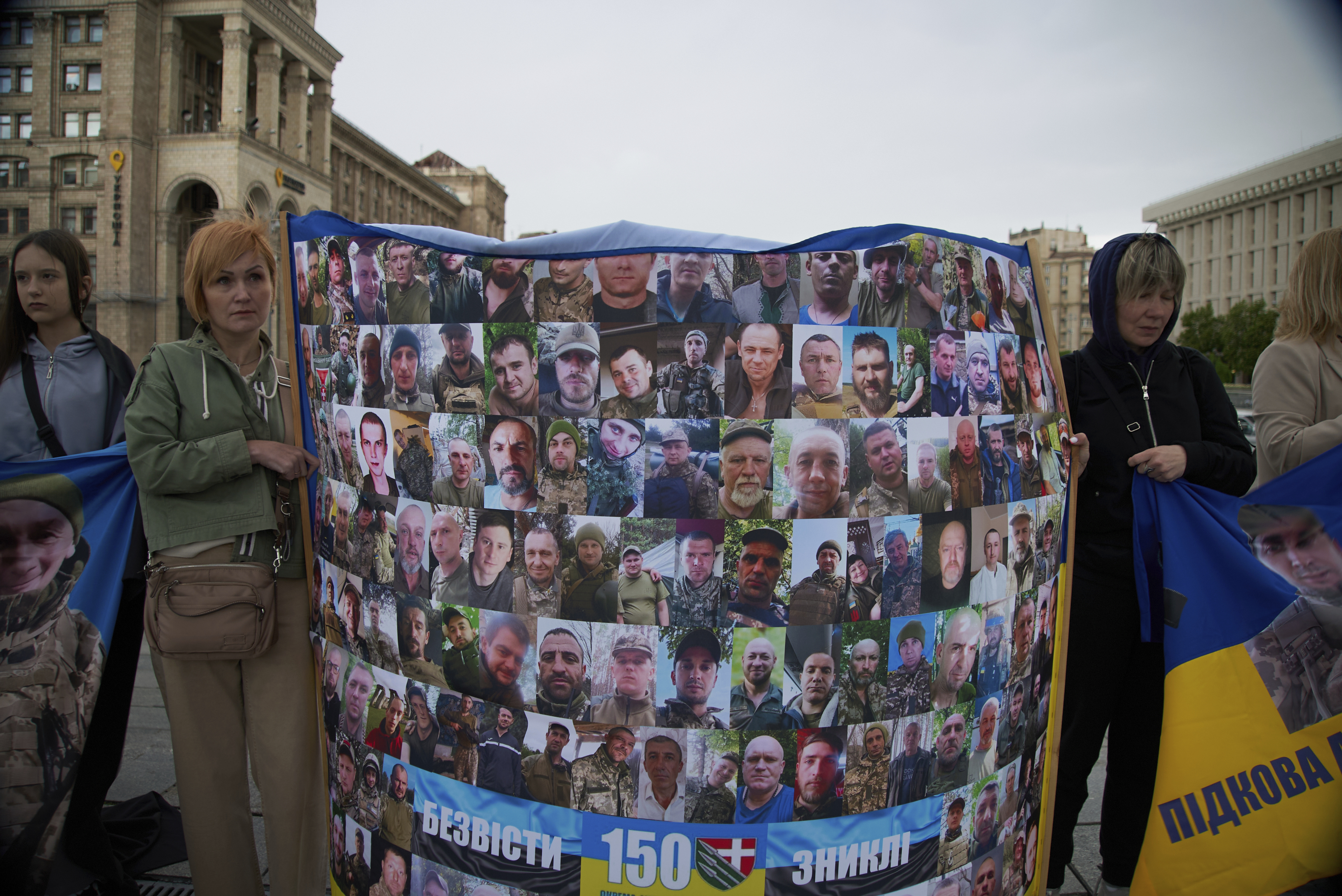 People with Ukrainian flags and banners attend a rally of families of missing soldiers from the Bakhmut garrison in Kyiv, Ukraine, Thursday, May 1, 2025. (AP Photo/Vasilisa Stepanenko)