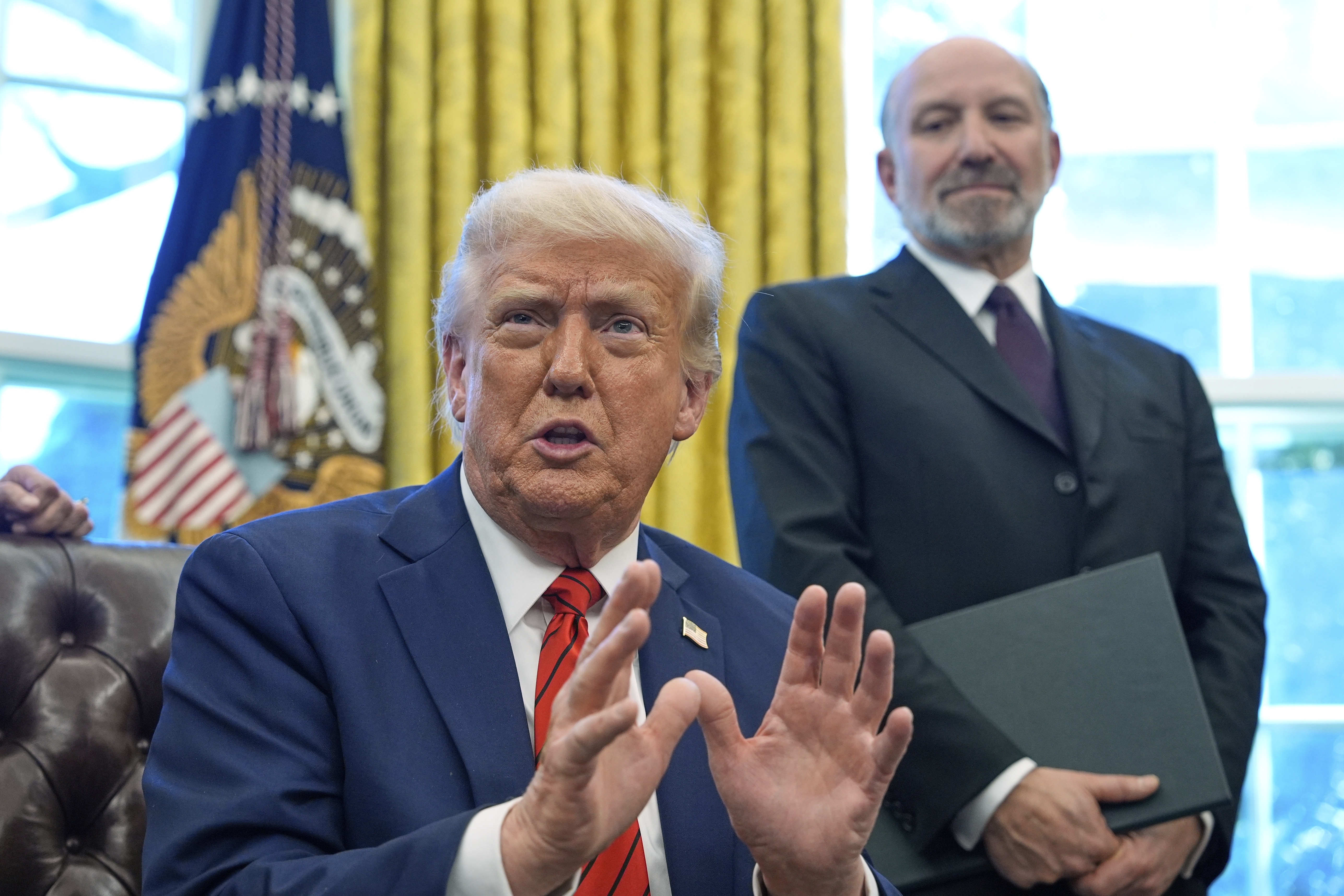 President Donald Trump speaks as he signs executive orders in the Oval Office of the White House, Thursday, April 17, 2025, in Washington, as Commerce Secretary Howard Lutnick listens. (AP Photo/Alex Brandon)