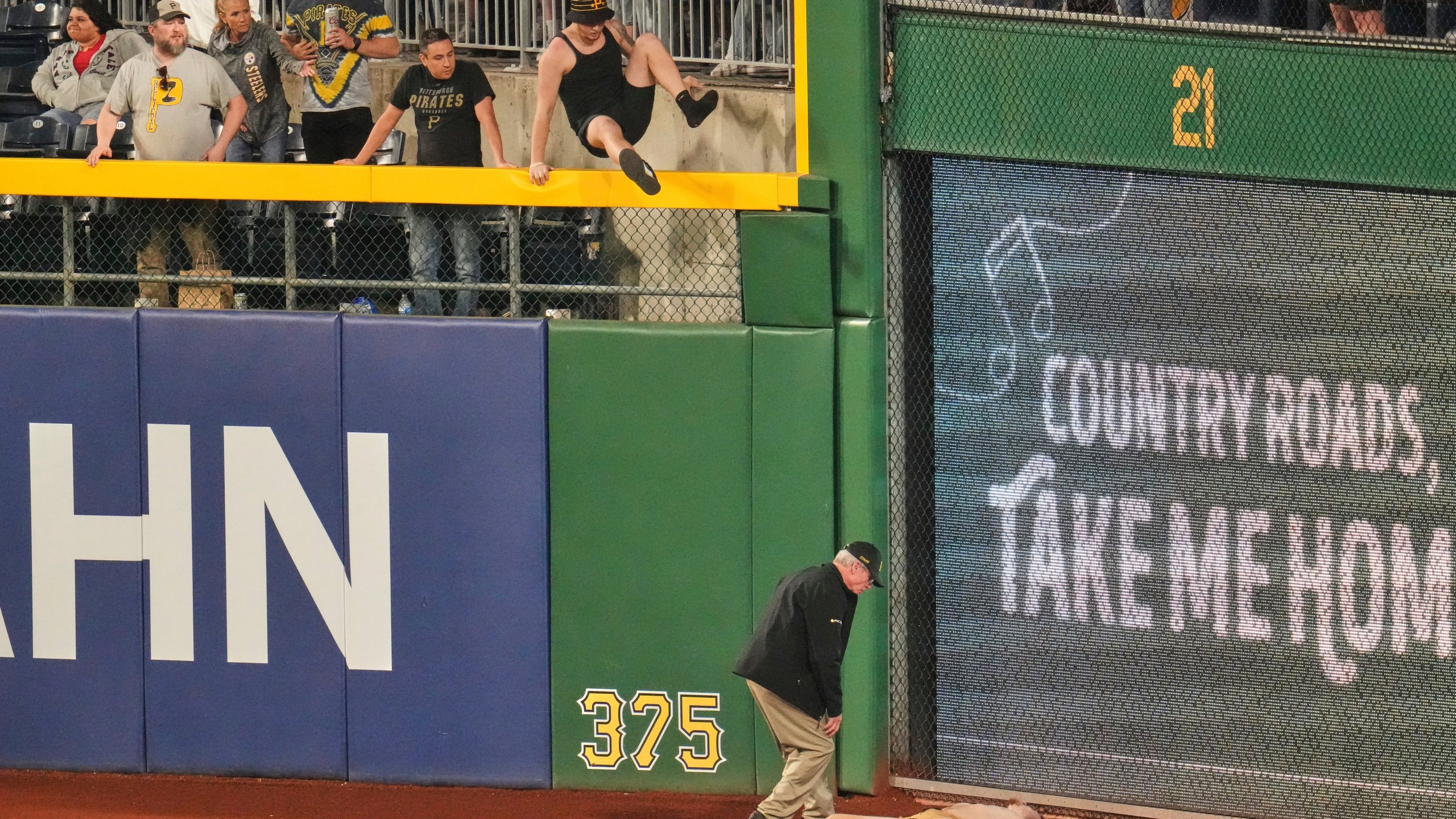 A fan lies on the warning track in right field of PNC Park after falling out of the stands during the seventh inning of a baseball game between the Pittsburgh Pirates and the Chicago Cubs in Pittsburgh, Wednesday, April 30, 2025. (AP Photo/Gene J. Puskar)