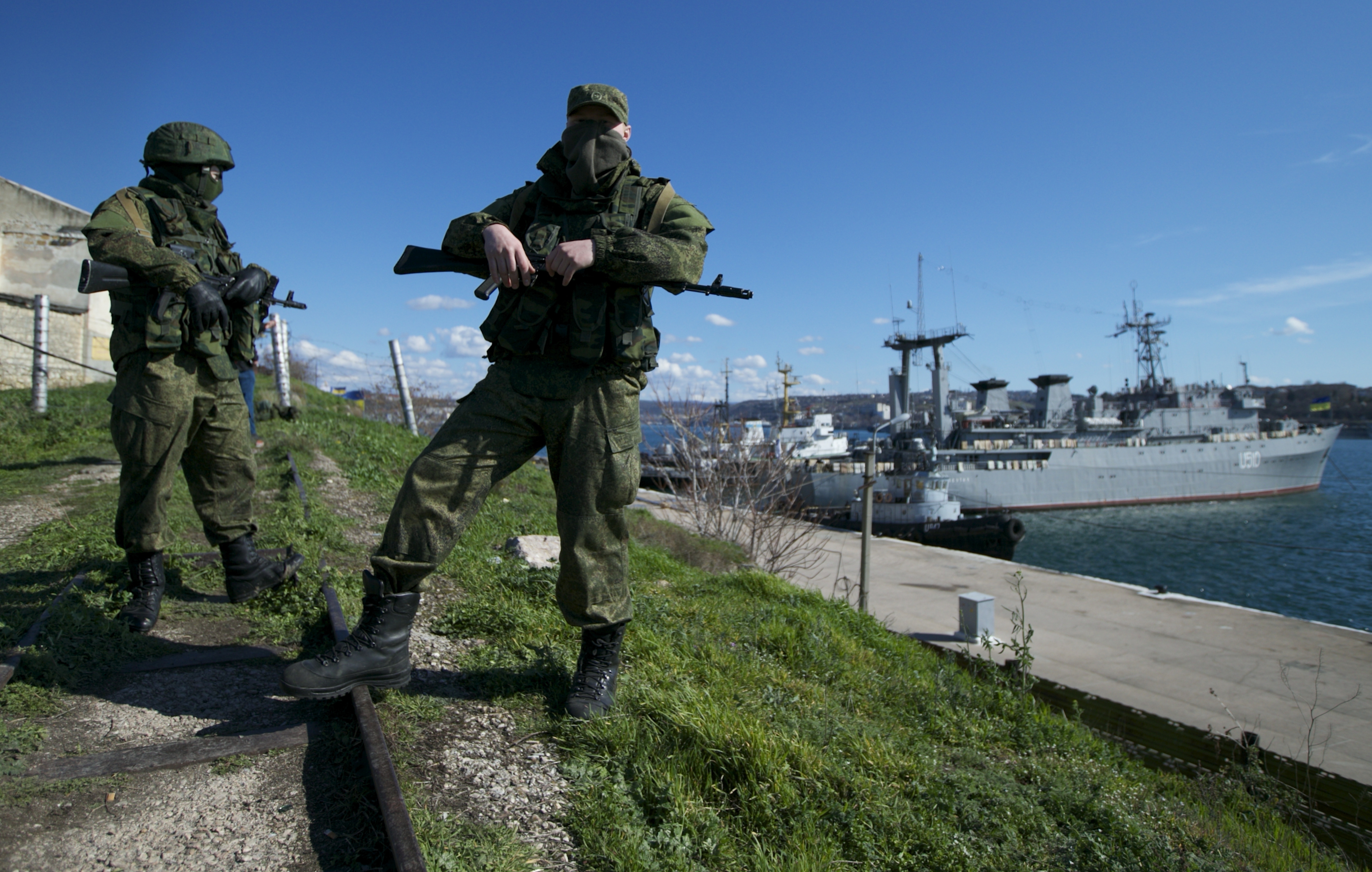 FILE - Russian soldiers guard a pier where two Ukrainian naval vessels are moored, in Sevastopol, on the Crimean Peninsula, March 5, 2014. (AP Photo, File)