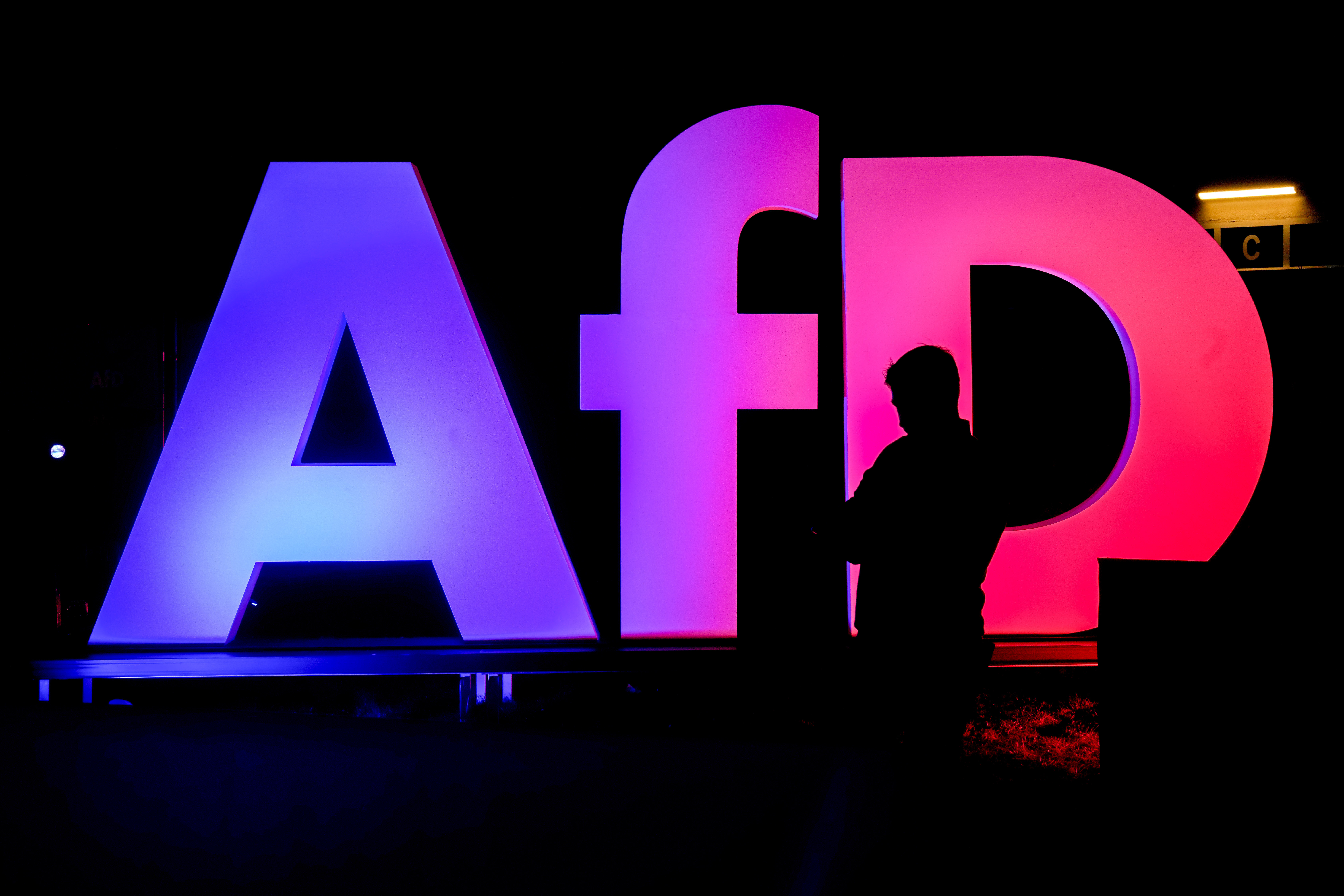 FILE - A man stands in front of the logo at the AfD party headquarters in Berlin, Germany, Sunday, Feb. 23, 2025, after the German national election. (AP Photo/Michael Probst, file)