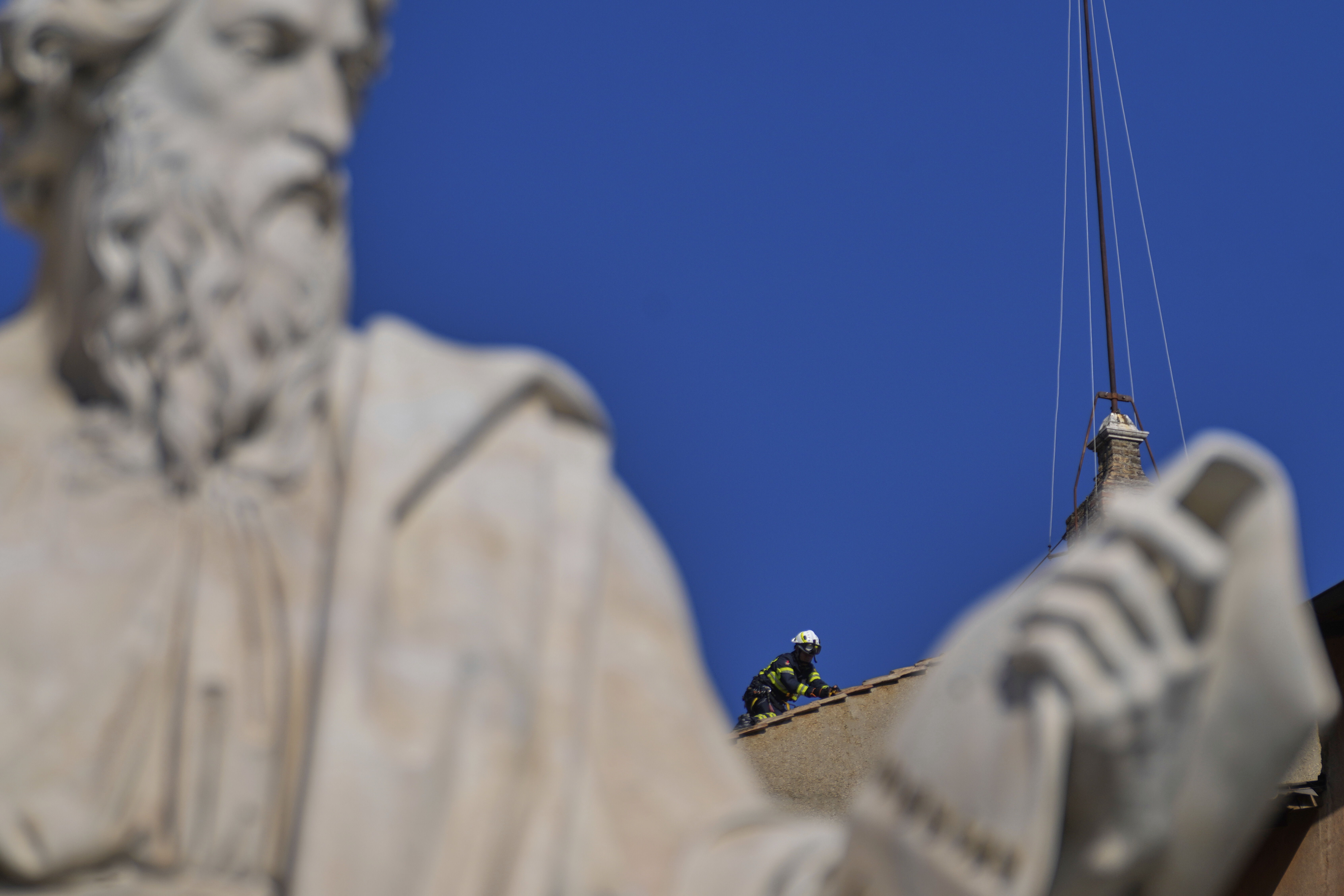 Firefighters place the chimney on the roof of the Sistine Chapel, where cardinals will gather to elect the new pope, at the Vatican, Friday, May 2, 2025. (AP Photo/Gregorio Borgia)