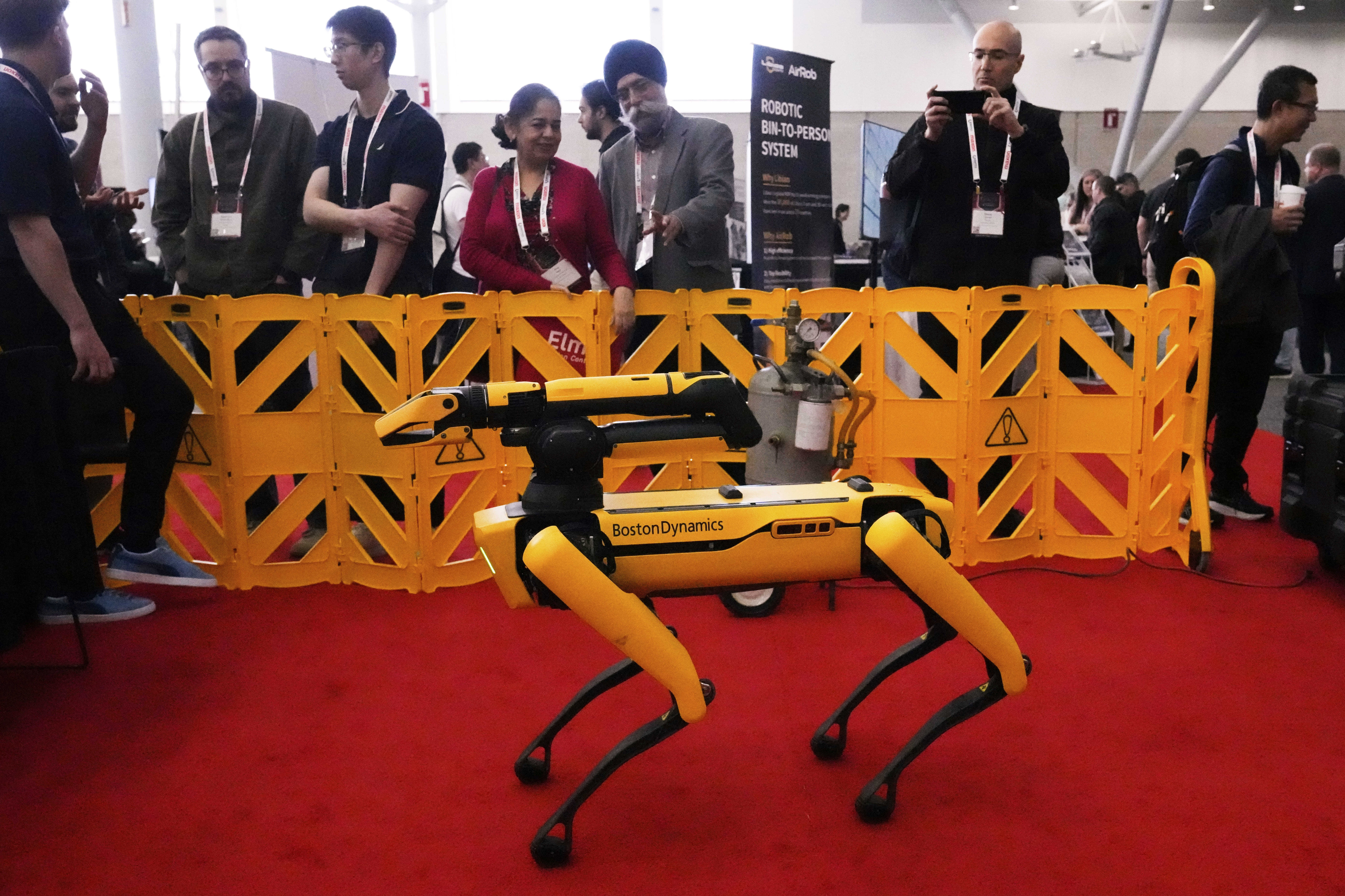 Convention guests watch as a Boston Dynamics robot is demontrated at the Robotics Summit & Expo, Wednesday, April 30, 2025, in Boston. (AP Photo/Charles Krupa)