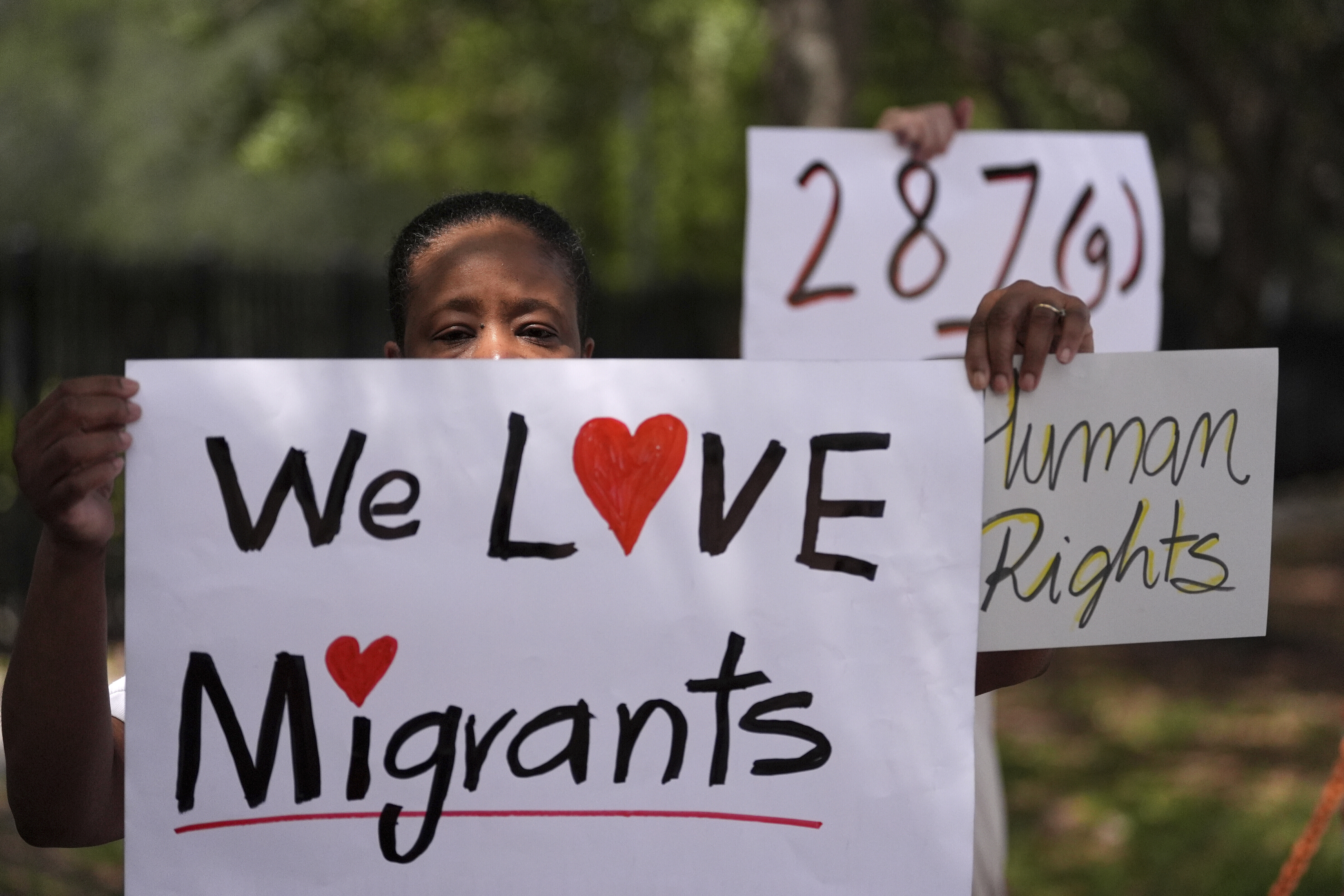 Advocates for migrant rights hold signs outside the South Florida office of U.S. Immigration and Customs Enforcement and Enforcement and Removal Operations, following a press conference with Gov. Ron DeSantis on immigration enforcement, May 1, 2025, in Miramar, Fla. (AP Photo/Rebecca Blackwell)
