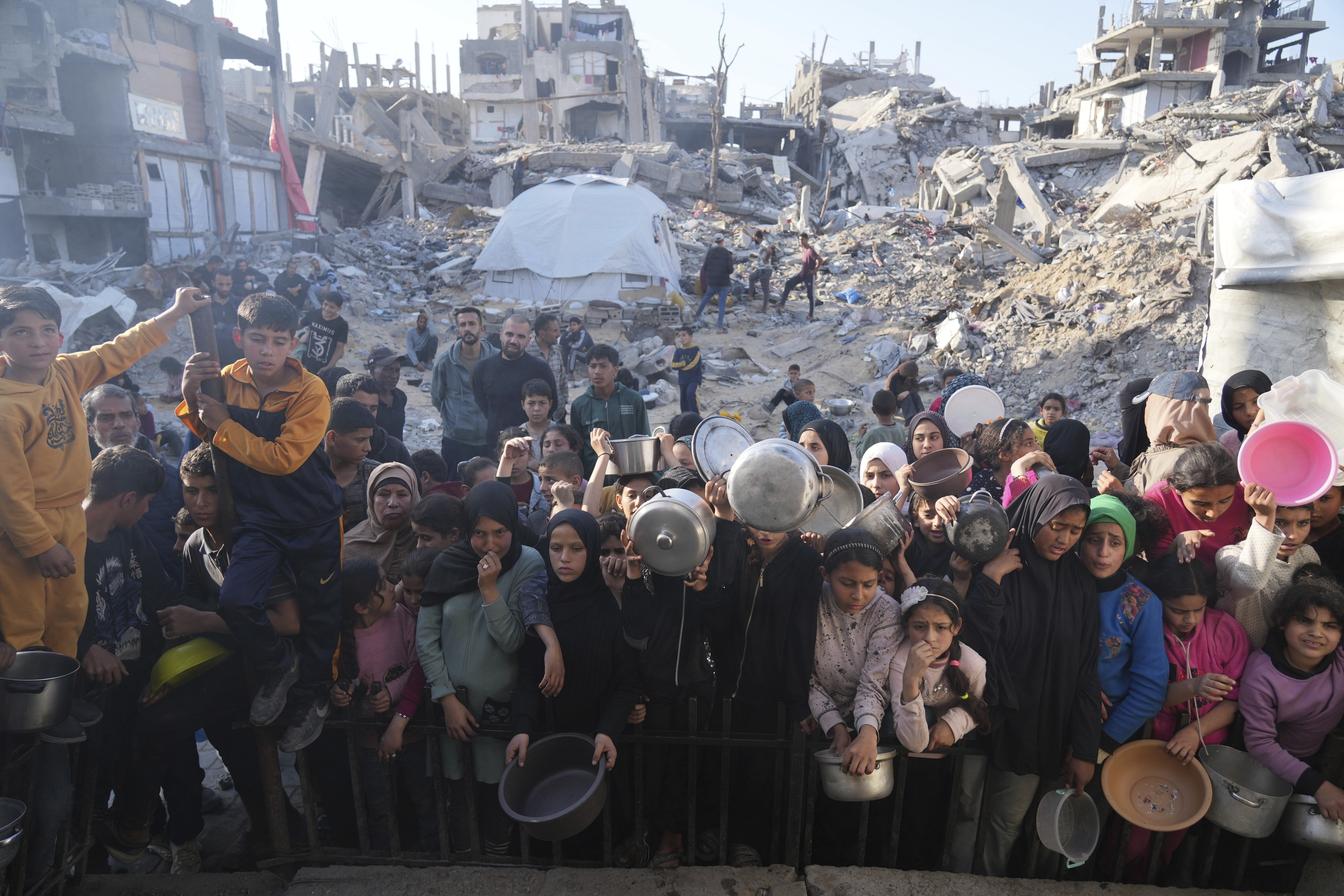 FILE.- Palestinians wait for donated food at a distribution center in Beit Lahiya, northern Gaza Strip, Sunday, March 16, 2025. (AP Photo/Abdel Kareem Hana,File)