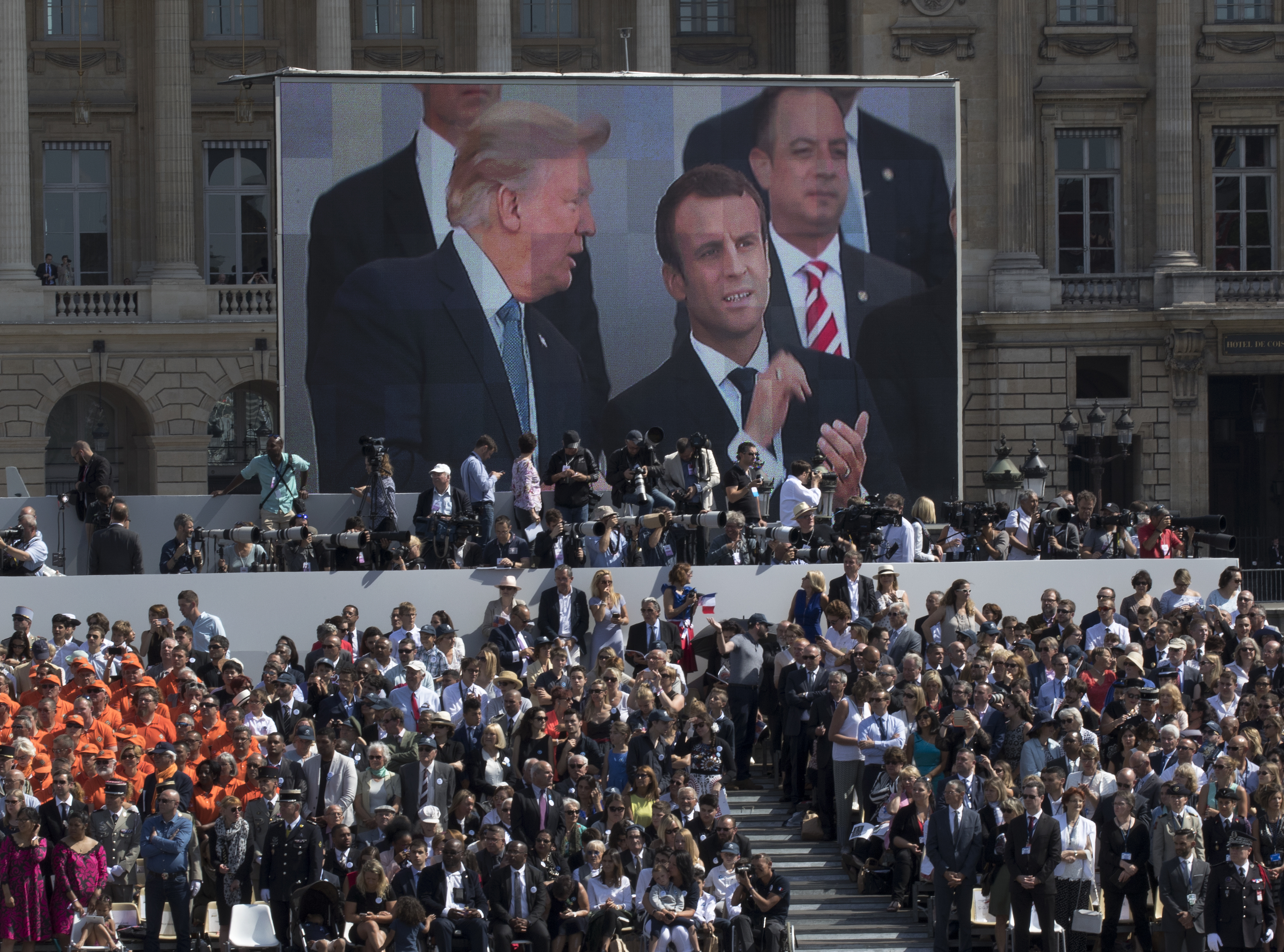 FILE - President Donald Trump, pictured on screen from left, French President Emmanuel Macron and White House Chief of Staff Reince Priebus watch a Bastille Day parade on the Champs Elysees avenue in Paris, July 14, 2017. (AP Photo/Carolyn Kaster, File)