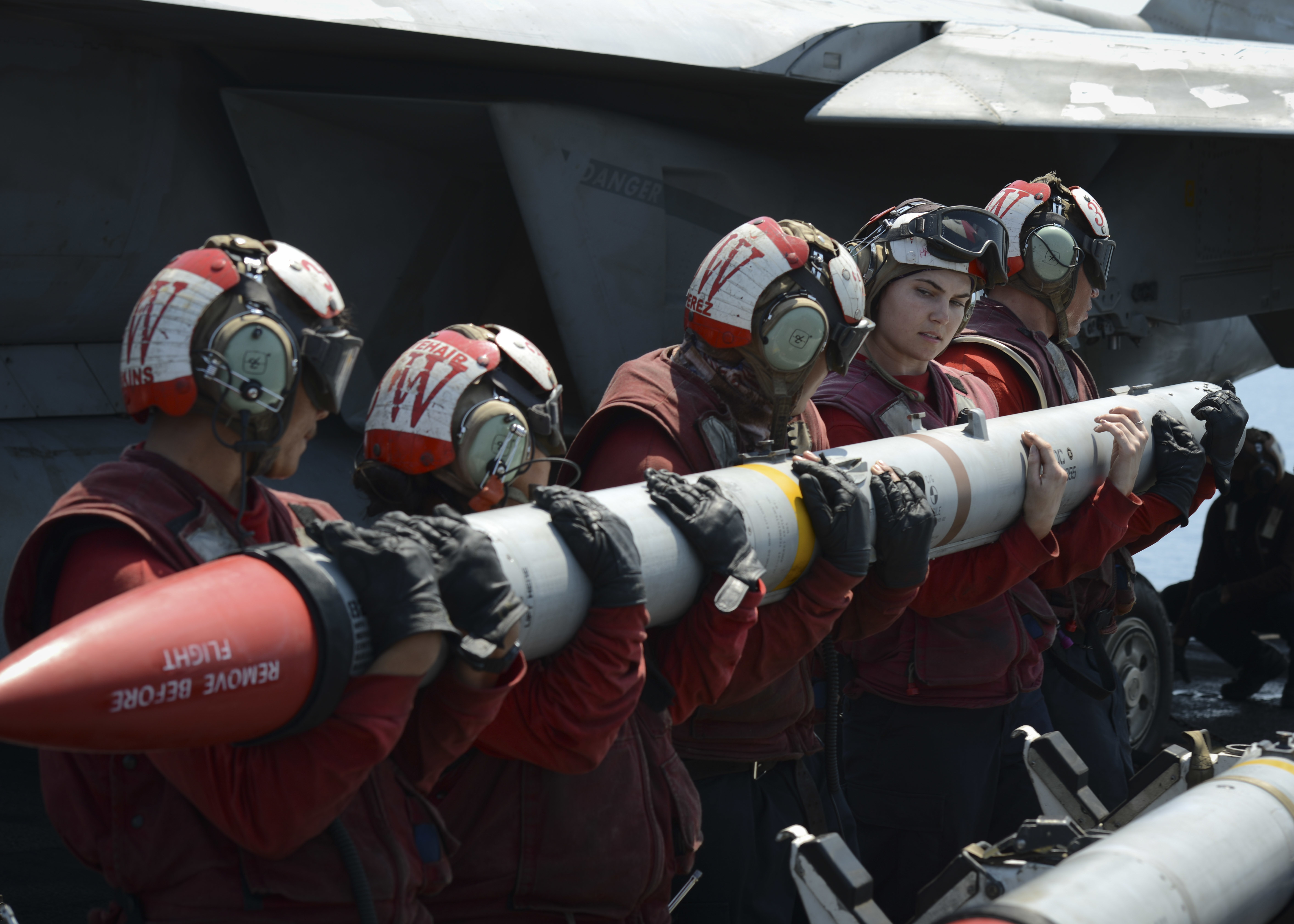 In this handout photo from the U.S. Navy, sailors load an AIM-120C missile into an F/A-18E Super Hornet aboard the aircraft carrier USS Nimitz in the Persian Gulf on Aug. 8, 2017. (Mass Communication Specialist 3rd Class Weston A. Mohr/U.S. Navy via AP)