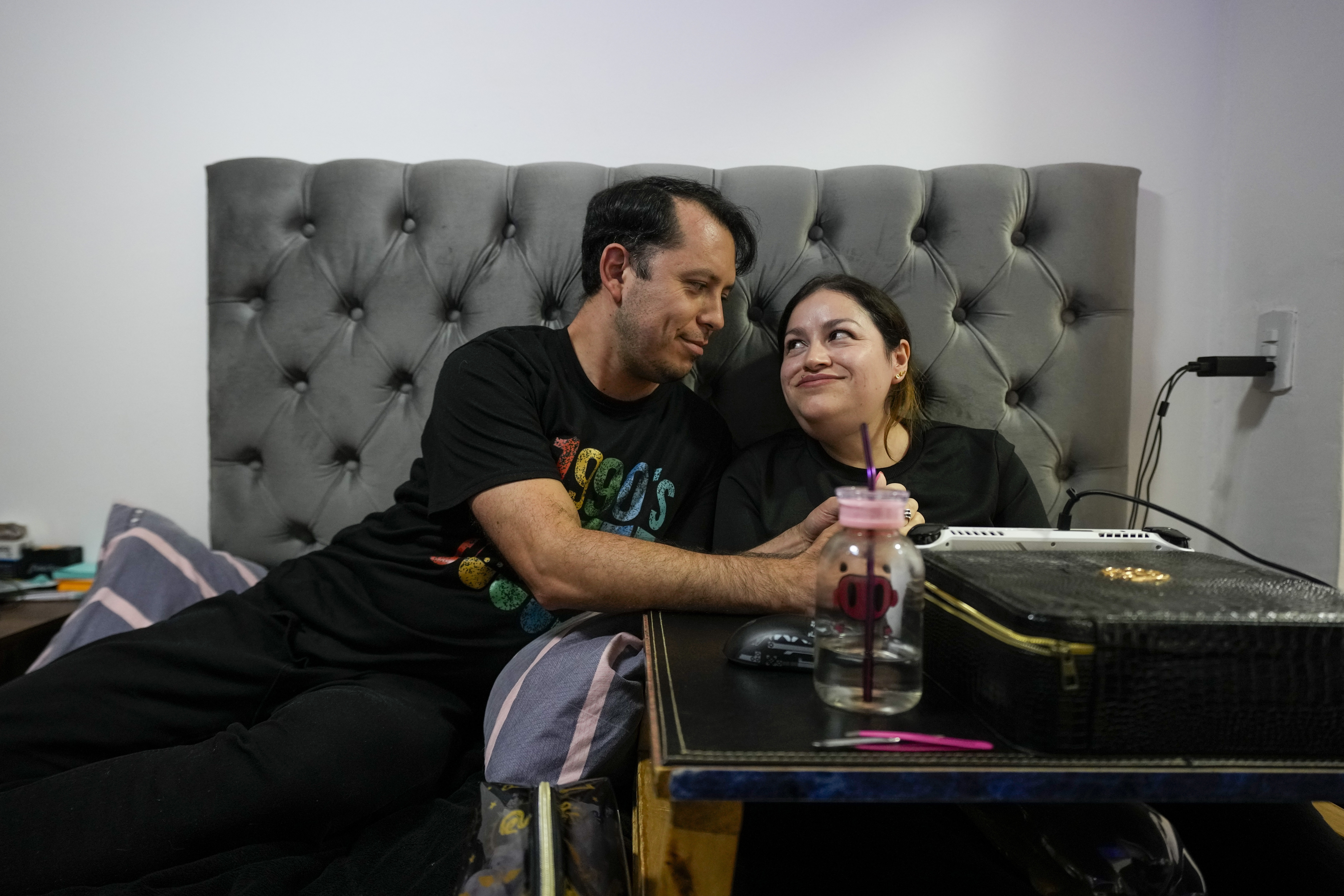 Susana Moreira, 41, a degenerative muscular dystrophy patient, looks at her husband in her bedroom in Santiago, Chile, Thursday, April 10, 2025. (AP Photo/Esteban Felix)