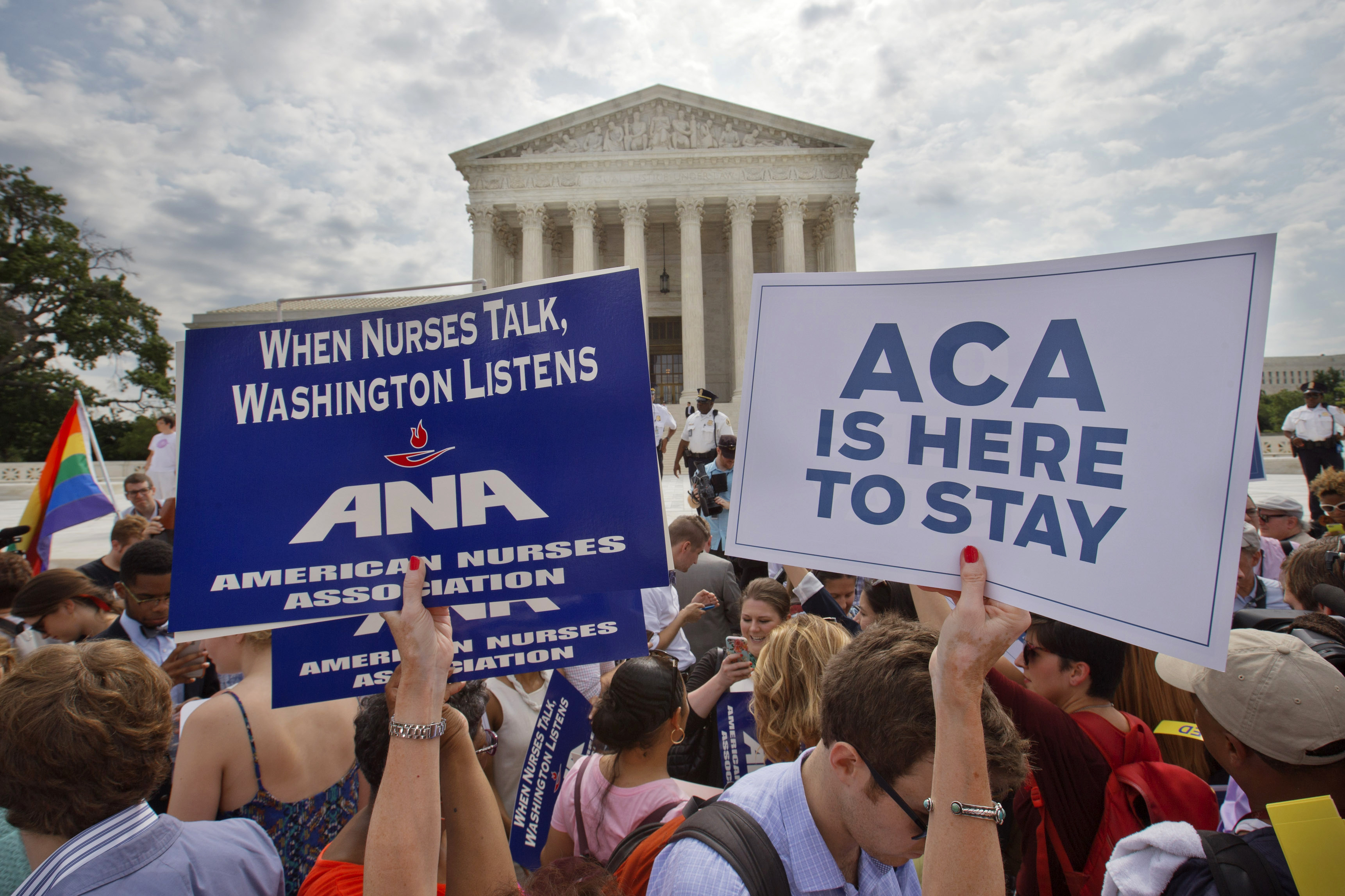 FILE - Supporters of the Affordable Care Act hold up signs as the opinion for health care is reported outside of the Supreme Court in Washington, June 25, 2015. The Supreme Court on Thursday upheld the nationwide tax subsidies under President Barack Obama's health care overhaul, in a ruling that preserves health insurance for millions of Americans. (AP Photo/Jacquelyn Martin, File)