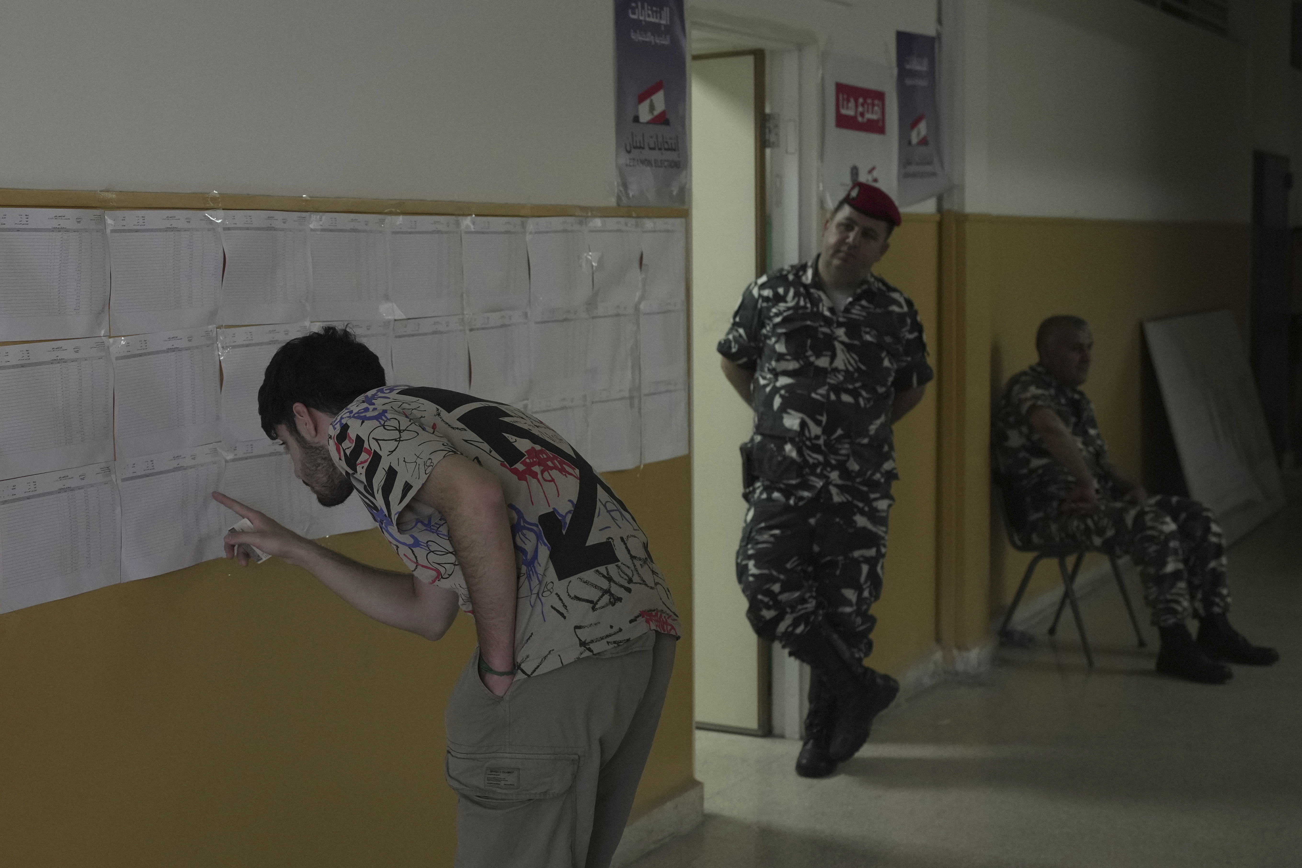 A Lebanese man checks a polling list for his name before voting at a polling station during municipal elections in the southern suburbs of Beirut, Lebanon, Sunday, May 4, 2025. (AP Photo/Hassan Ammar)