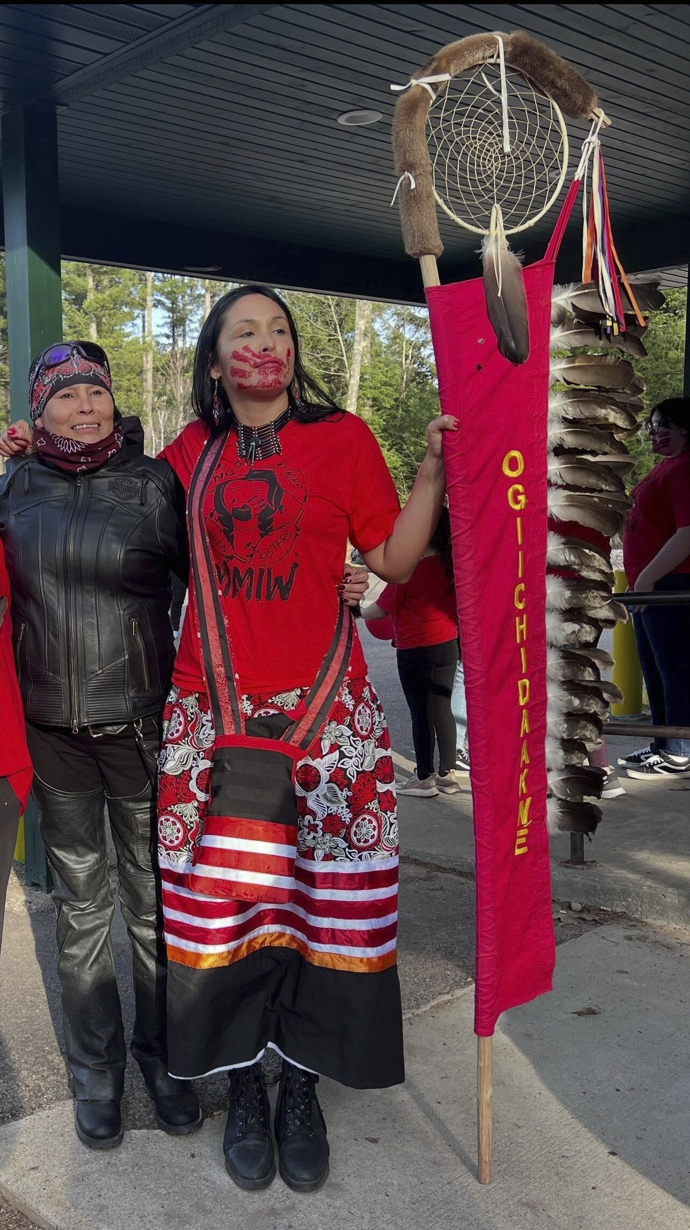 In this photo provided by Shawn Milligan, motorcycle rider Lisa Milligan of the Forest County Potawatomi tribe poses with a young activist at a Missing & Murdered Indigenous Women event at the Lac du Flambeau Band of Lake Superior Chippewa reservation in Wisconsin, May 5, 2022. (Shawn Milligan via AP)