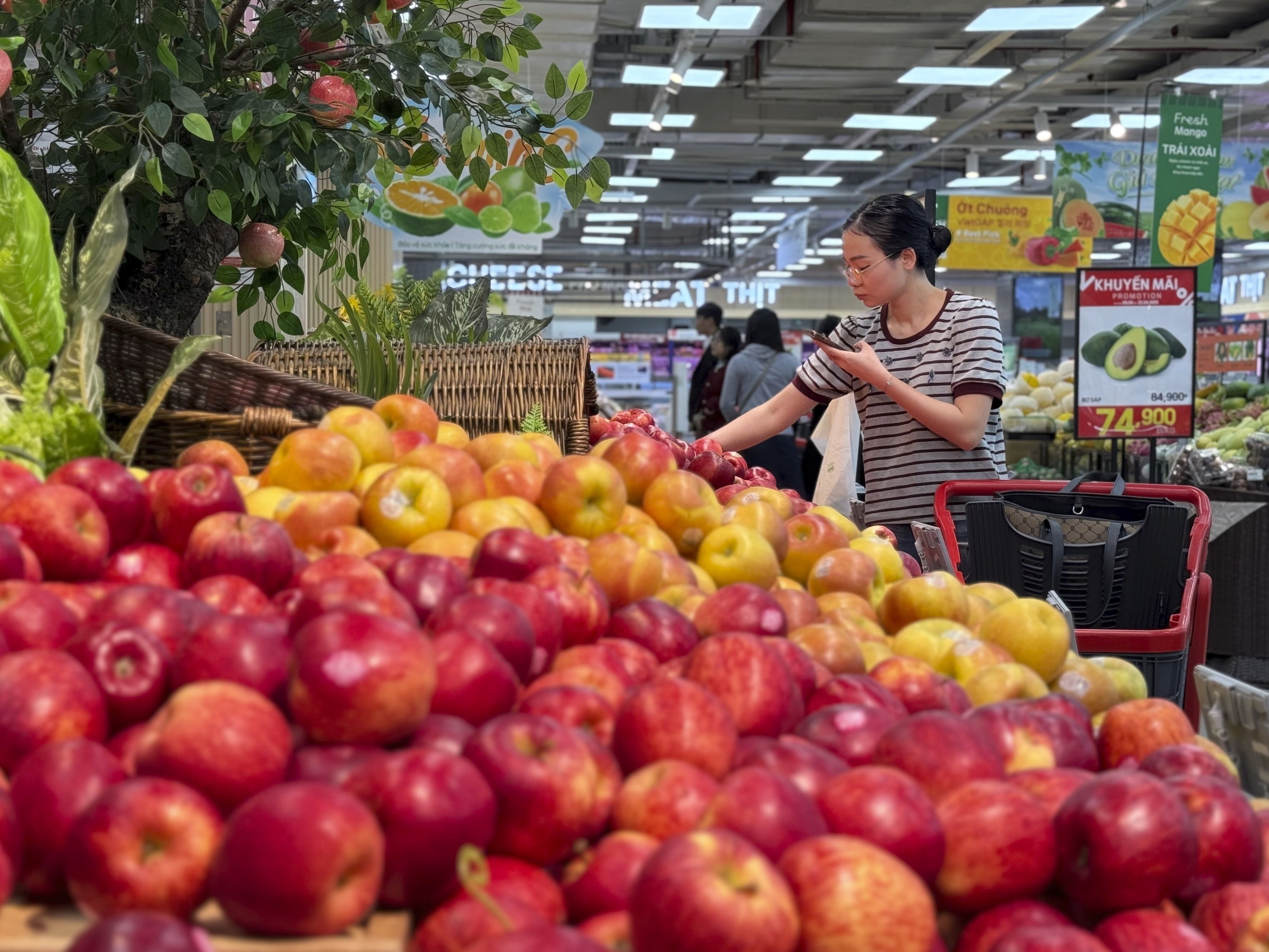 FILE - A shopper picks up imported apples at a supermarket in Hanoi, Vietnam on Thursday, April 10, 2025. (AP Photo/Hau Dinh, File)