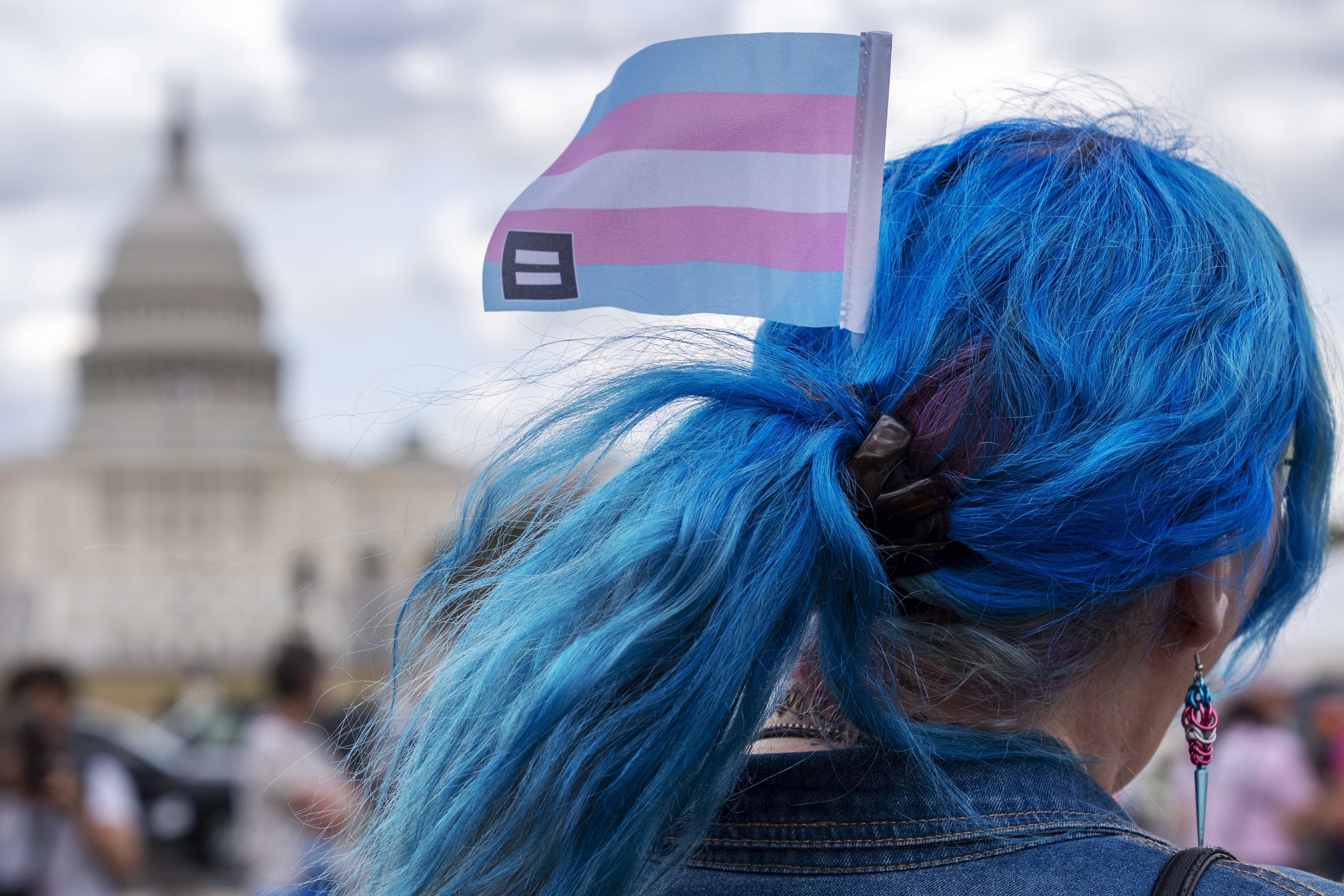 FILE - With the Capitol in the background, Kali wears a trans equality flag in her hair while attending a rally for the Trans Day of Visibility on the National Mall, March 31, 2025, in Washington. (AP Photo/Jacquelyn Martin, File)