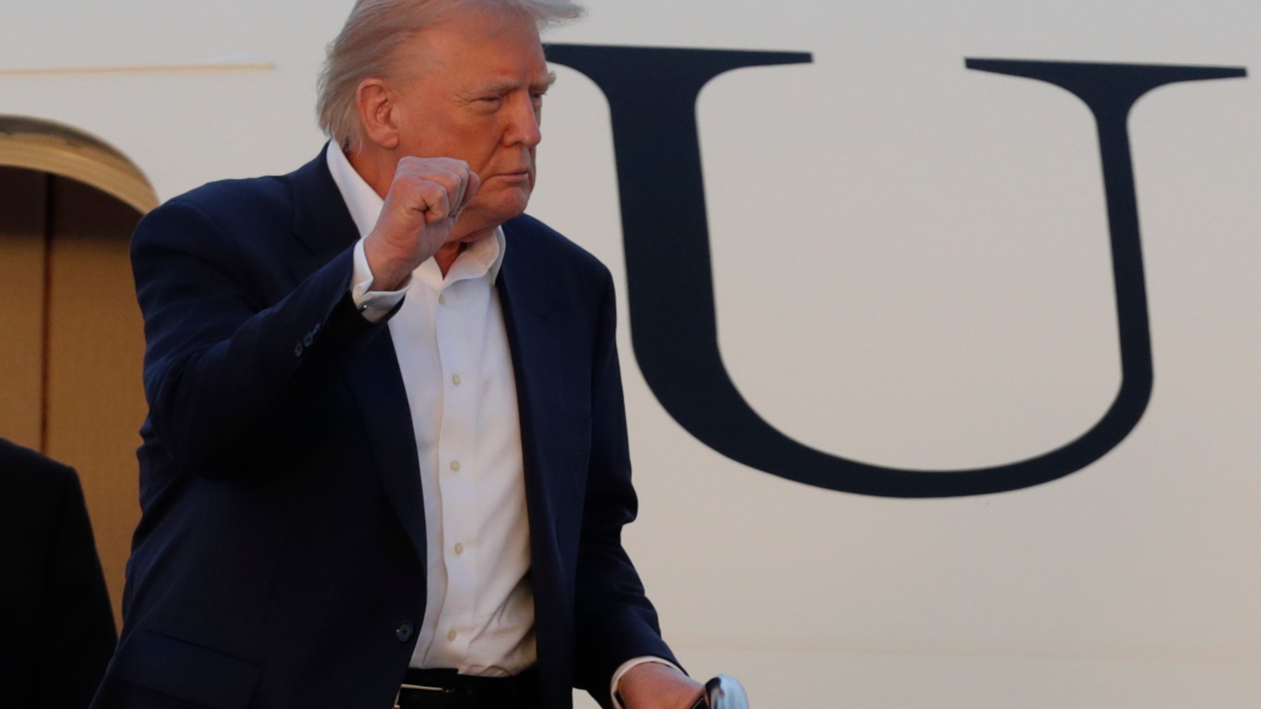 President Donald Trump gestures from the stairs of Air Force One upon his arrival at Joint Base Andrews, Md., Sunday, May 4, 2025. (AP Photo/Luis M. Alvarez)
