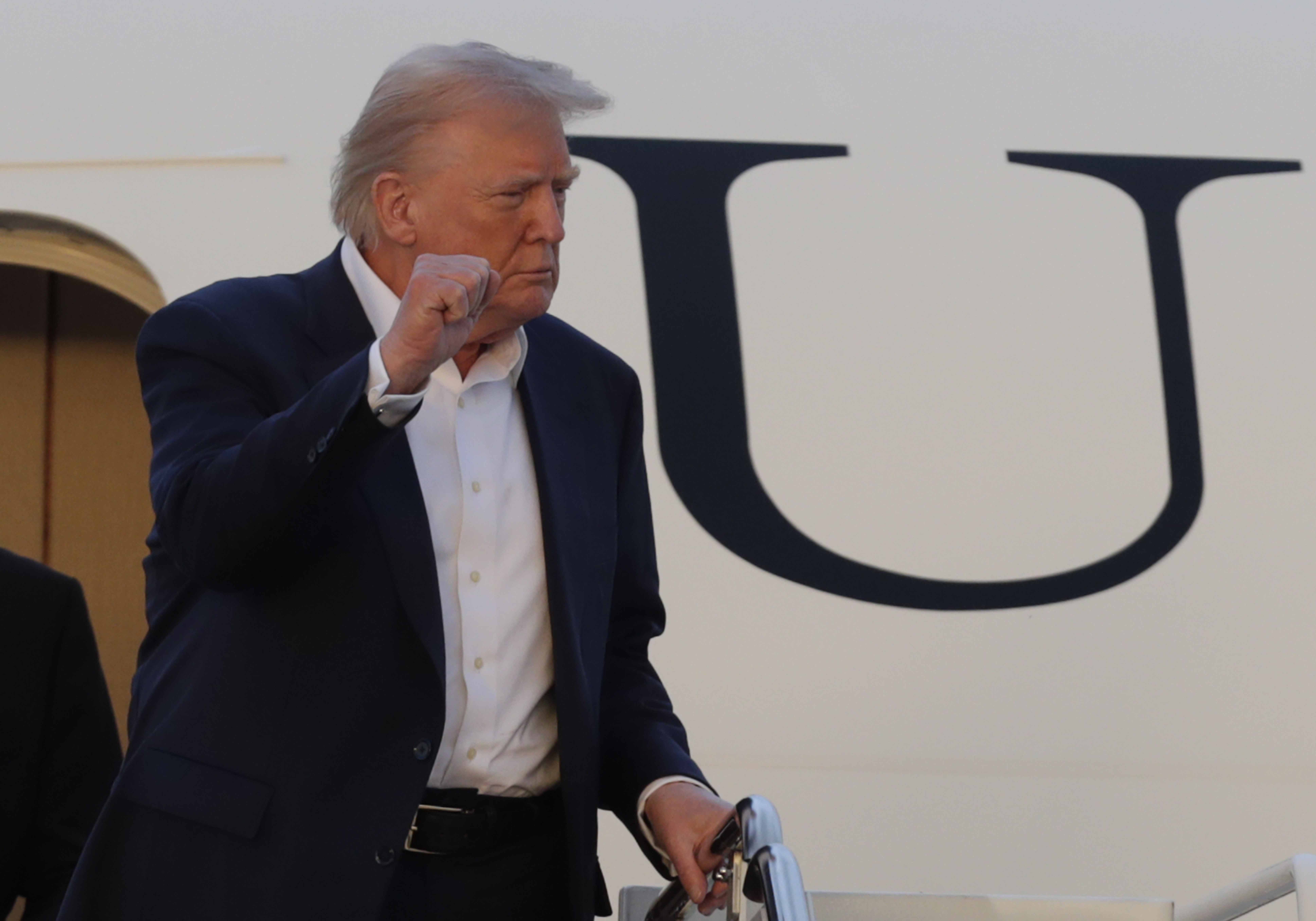 President Donald Trump gestures from the stairs of Air Force One upon his arrival at Joint Base Andrews, Md., Sunday, May 4, 2025. (AP Photo/Luis M. Alvarez)