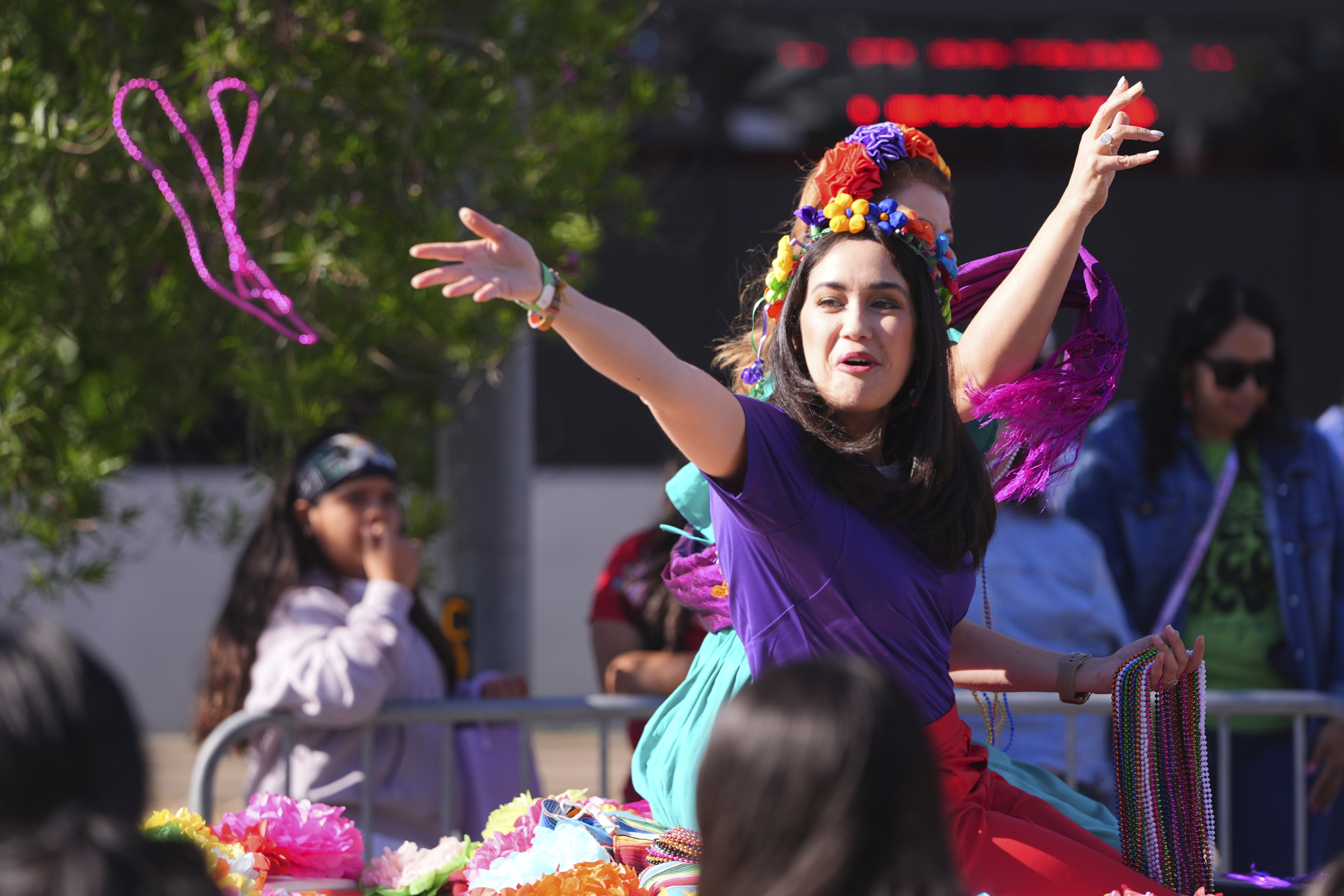 Beads are tossed from a float during a Cinco de Mayo parade in the Oak Cliff section of Dallas, Saturday, May 3, 2025. (AP Photo/LM Otero)