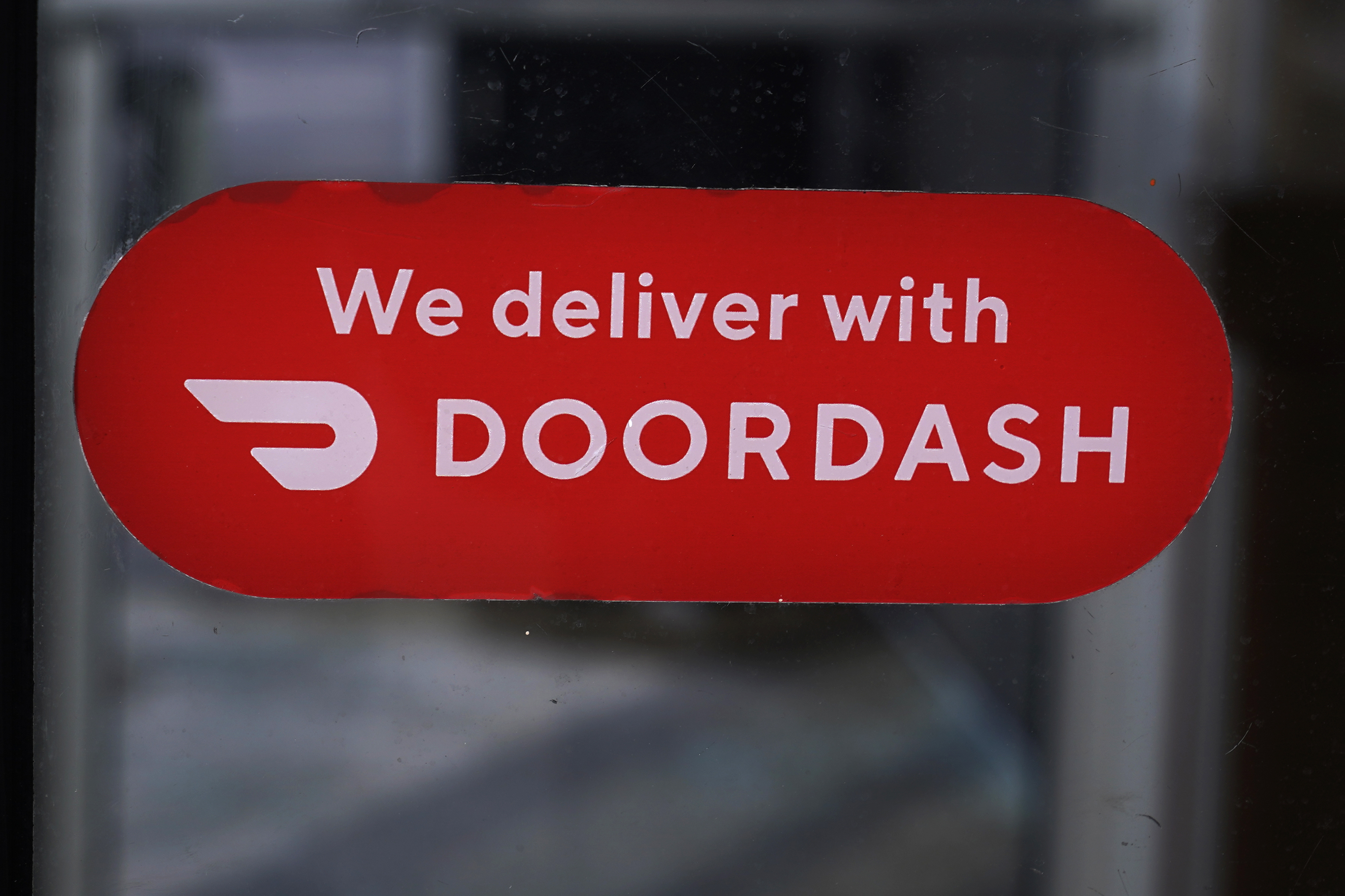FILE - A DoorDash sign is posted on the door of a Dunkin' Donuts franchise, Feb. 27, 2023, in Methuen, Mass. (AP Photo/Charles Krupa, File)
