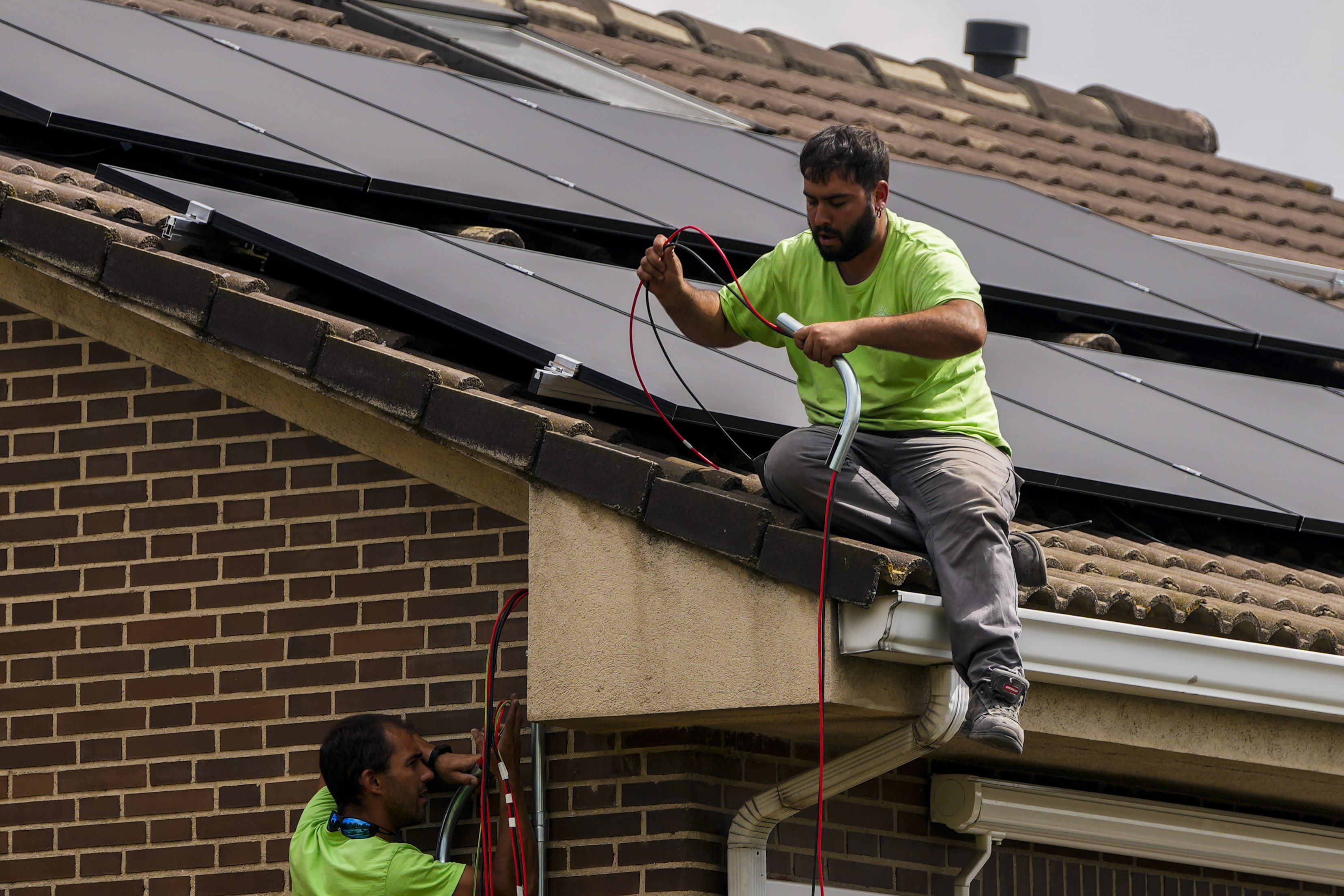 FILE - Workers install solar planers on the roof of a house in Rivas Vaciamadrid, Spain, Thursday, Sept. 15, 2022. (AP Photo/Manu Fernandez, File)