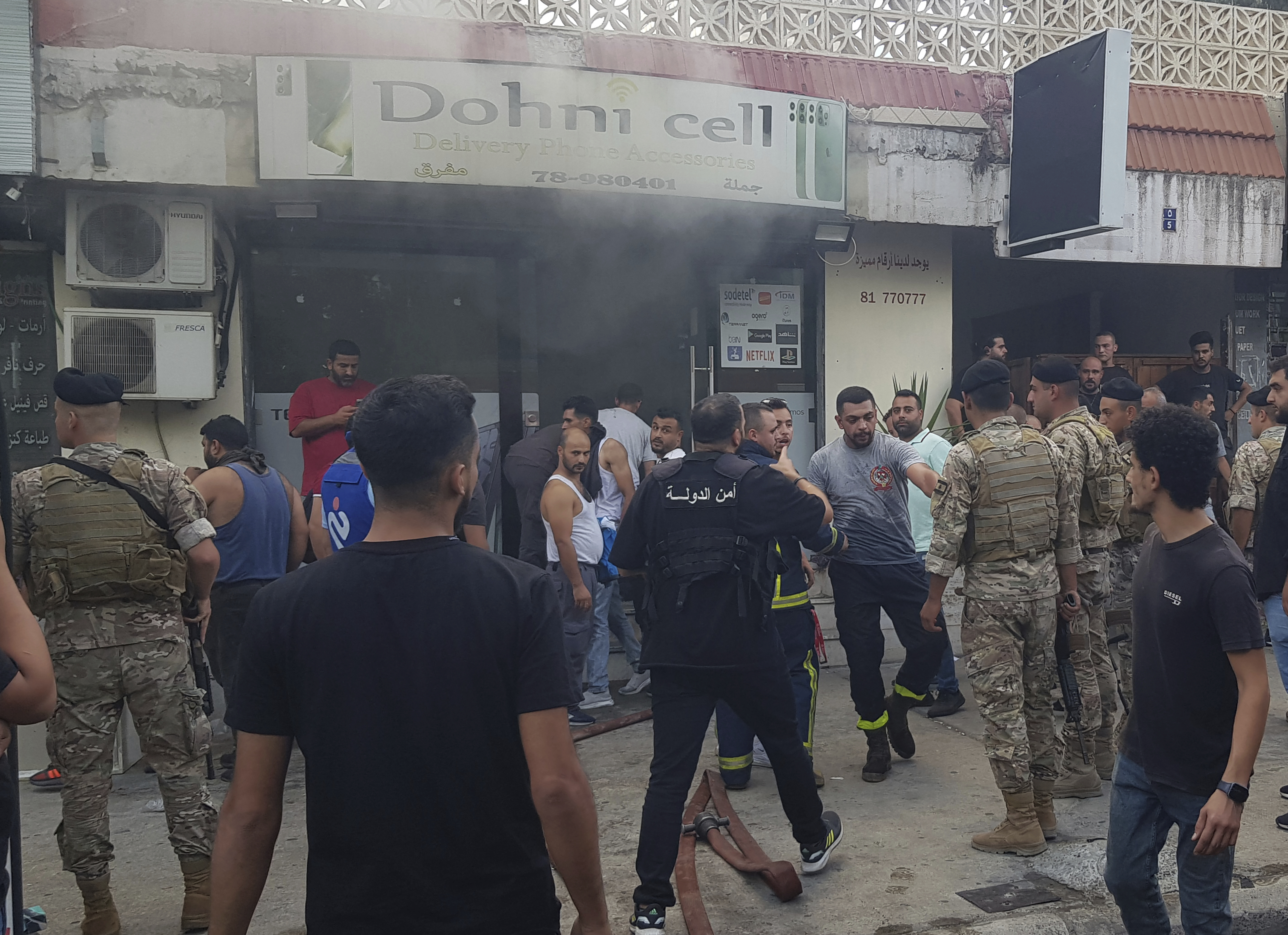 FILE - Lebanese soldiers and firefighters gather outside a mobile shop after what is believed to be the result of a walkie-talkie exploding inside it, in the southern port city of Sidon, Lebanon, Wednesday, Sept. 18, 2024. (AP Photo/Mohammed Zaatari, File)