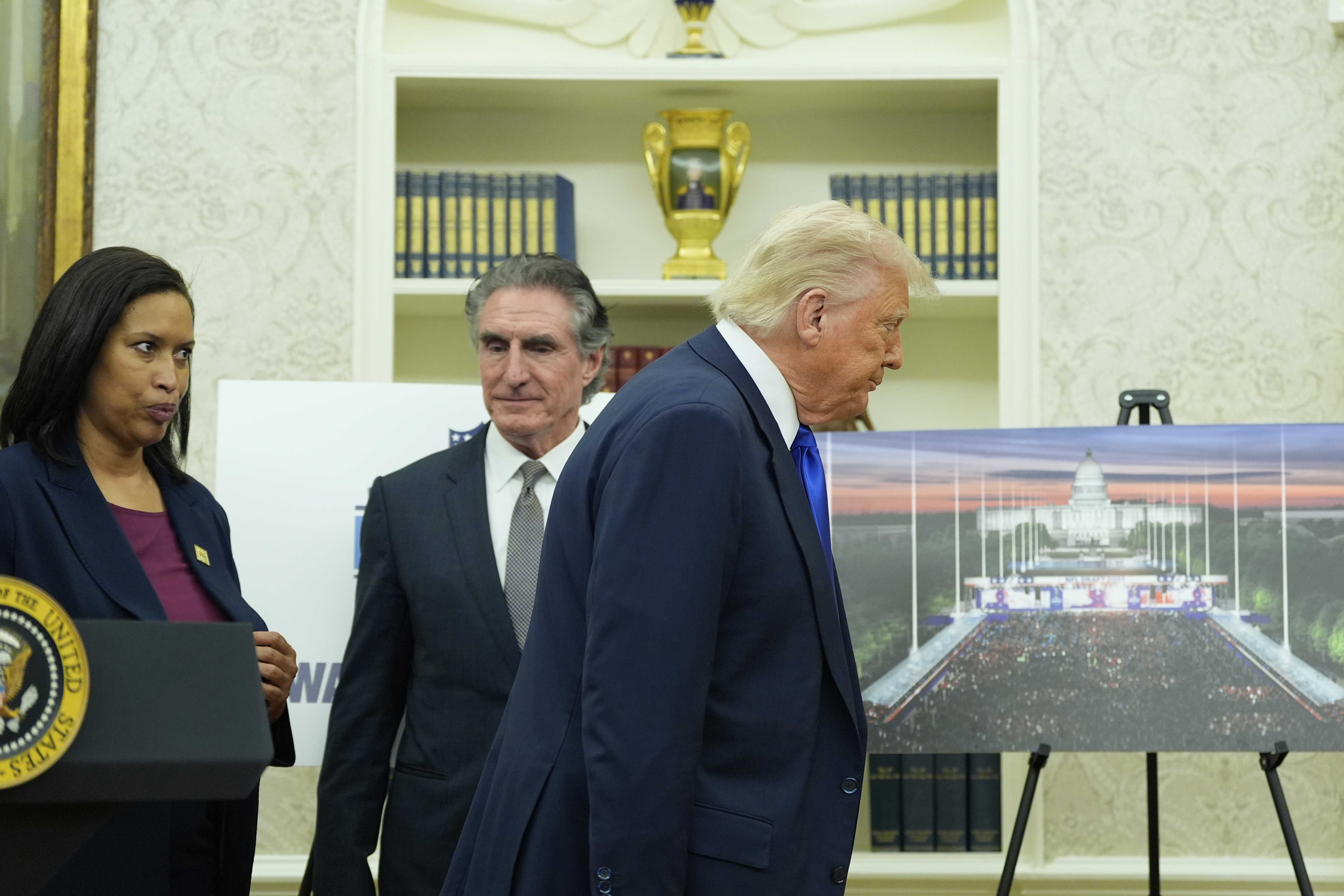 President Donald Trump, from right, departs as Interior Secretary Doug Burgum and District of Columbia Mayor Muriel Bowser look on after an event to announce that the 2027 NFL Draft will be held on the National Mall, in the Oval Office of the White House, Monday, May 5, 2025, in Washington. (AP Photo/Alex Brandon)