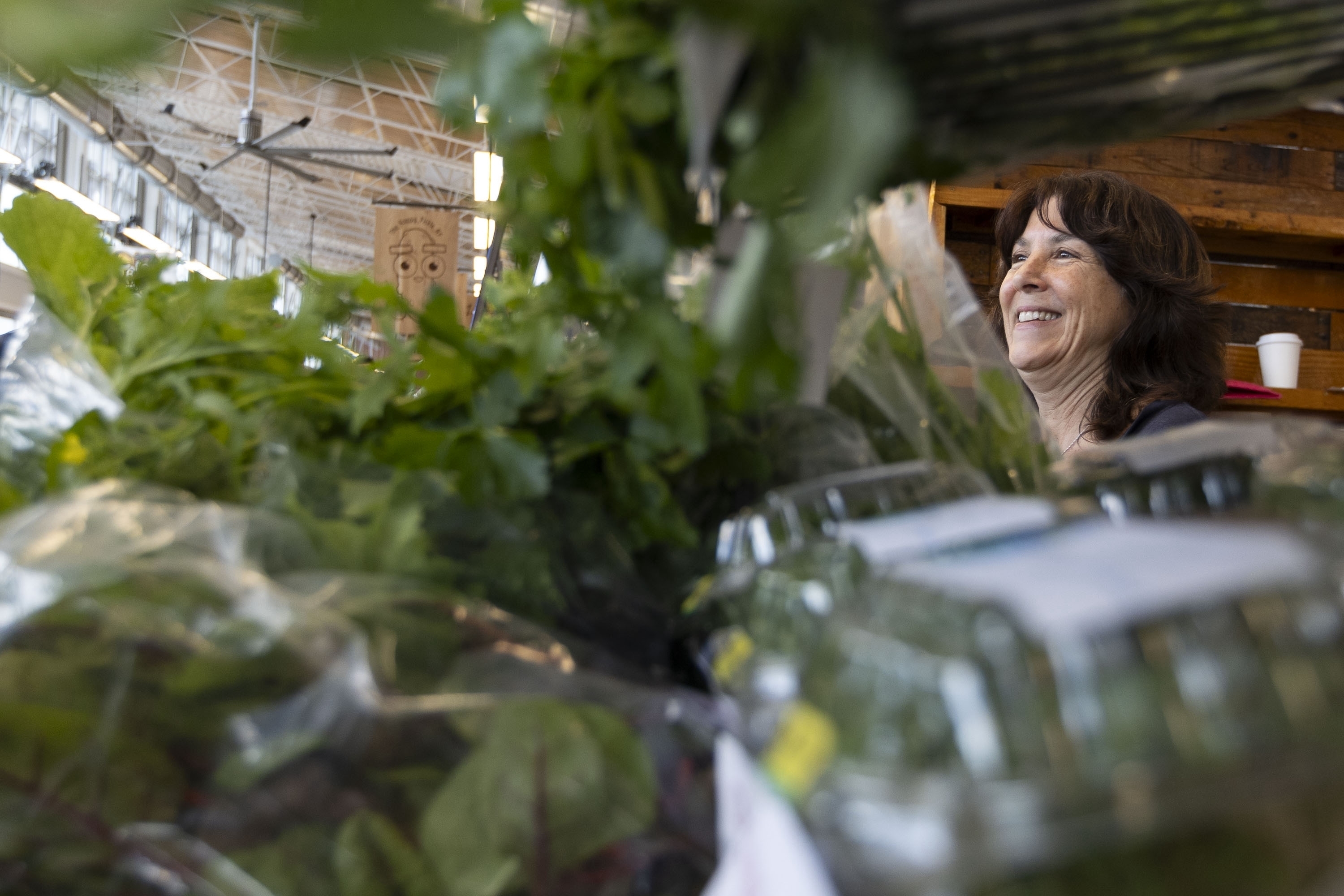 Alison Venuti, who goes by Sunny, an employee of Bolton Farms, laughs as she speaks with a customer at the Rochester Public Market on Saturday, March 22, 2025, in Rochester, N.Y. (Caitlyn Daproza via AP)