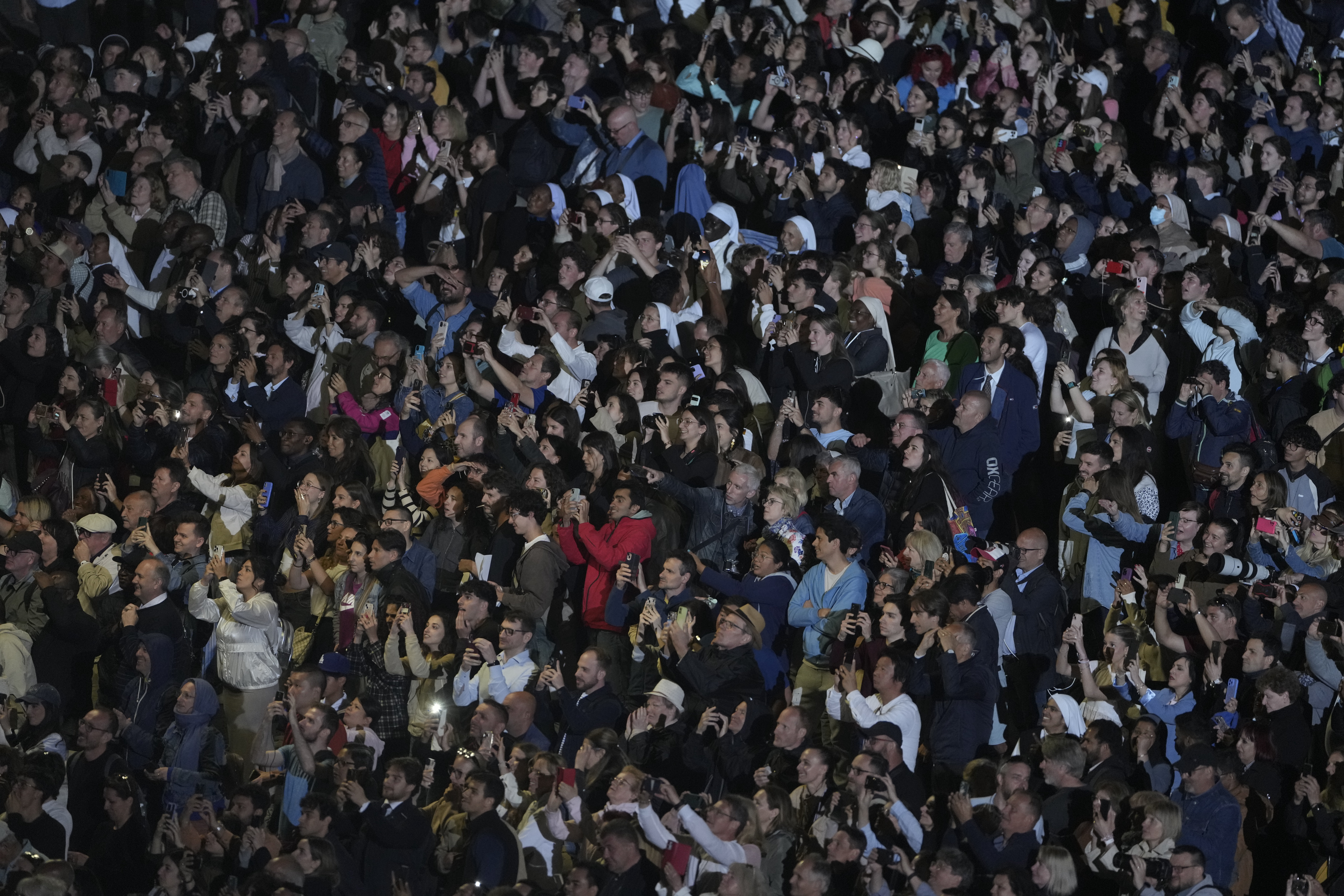 People react in St. Peter's Square at the Vatican after black smoke billowed from the chimney of the Sistine Chapel, where 133 cardinals are gathering on the first day of the conclave, indicating that a successor of late Pope Francis was not elected, Wednesday, May 7, 2025. (AP Photo/Markus Schreiber)