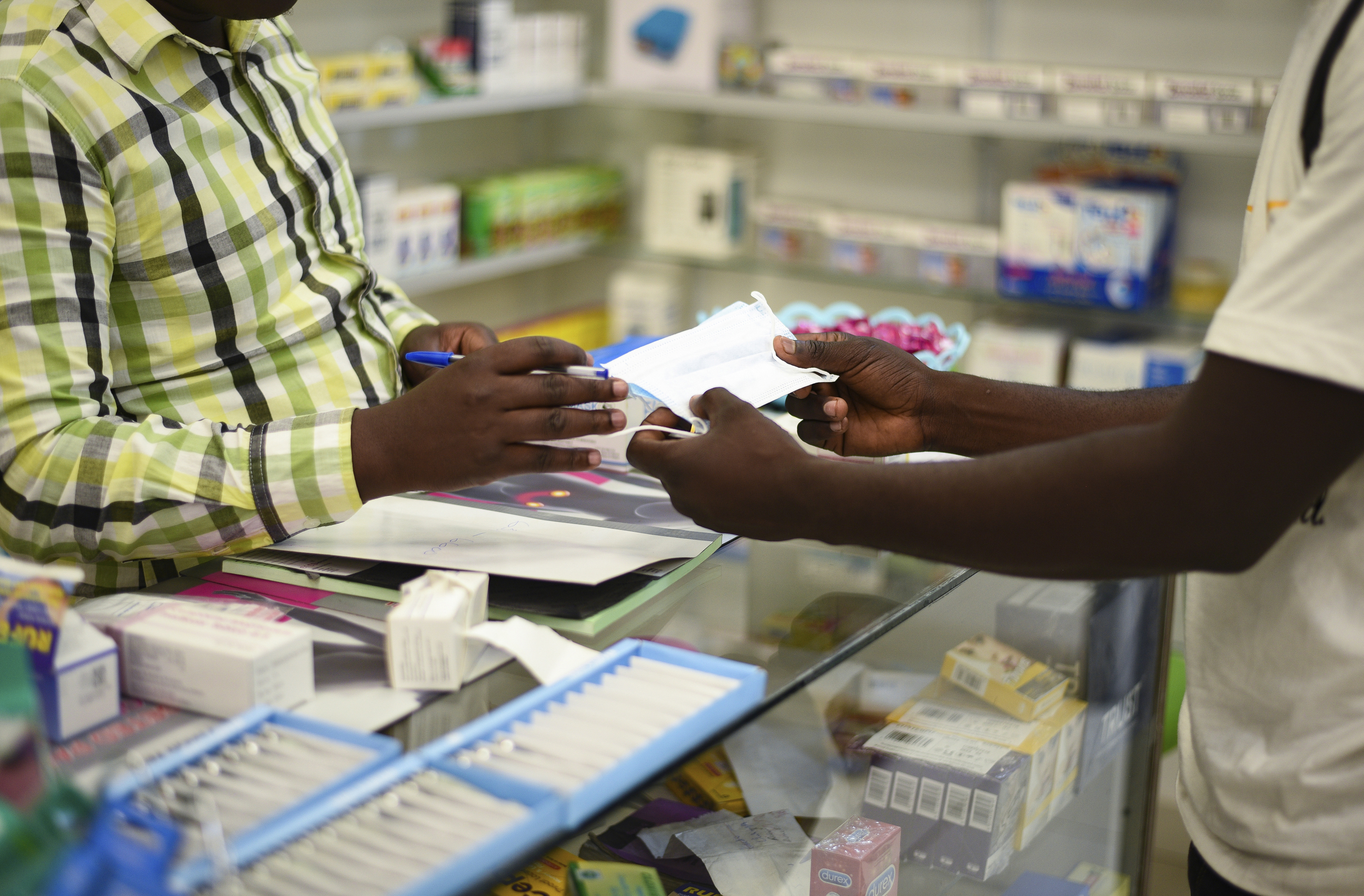 FILE — In this Feb. 6, 2020 file photo, a man buys a face mask at a pharmacy in Kitwe, Zambia. Zambia faces a Friday deadline to clear debt owed to external investors who have rejected the country's request for deferral of an overdue $42.5 million interest payment amid the coronavirus pandemic. (AP Photo/Emmanuel Mwiche/File)