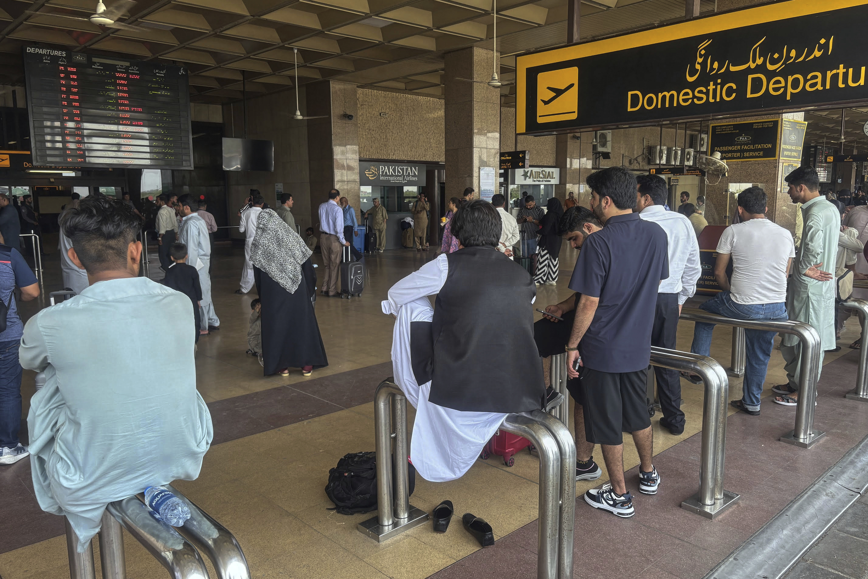 Stranded passengers wait at an arrival area of Jinnah airport after authorities closed the airport due to India's drone attack to Pakistan, in Karachi, Pakistan, Thursday, May 8, 2025. (AP Photo/Mohammad Farooq)