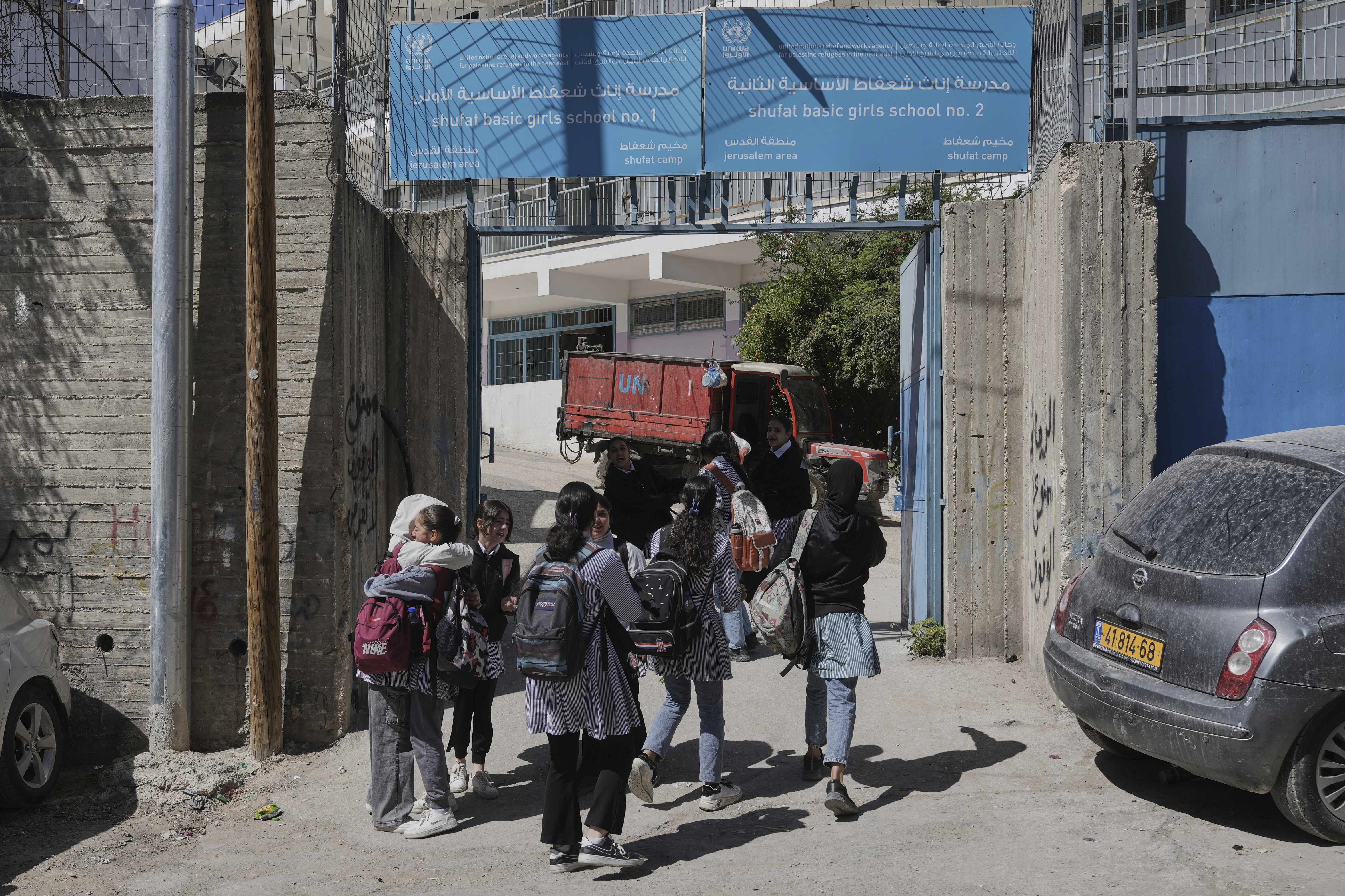 Students walk out of UNRWA Girls School run by the U.N. agency for Palestinian refugees in the Shuafat Refugee Camp in east Jerusalem, Thursday, May 8, 2025. After Israeli forces ordered the closure of six of its schools in east Jerusalem Thursday. (AP Photo/Mahmoud Illean)